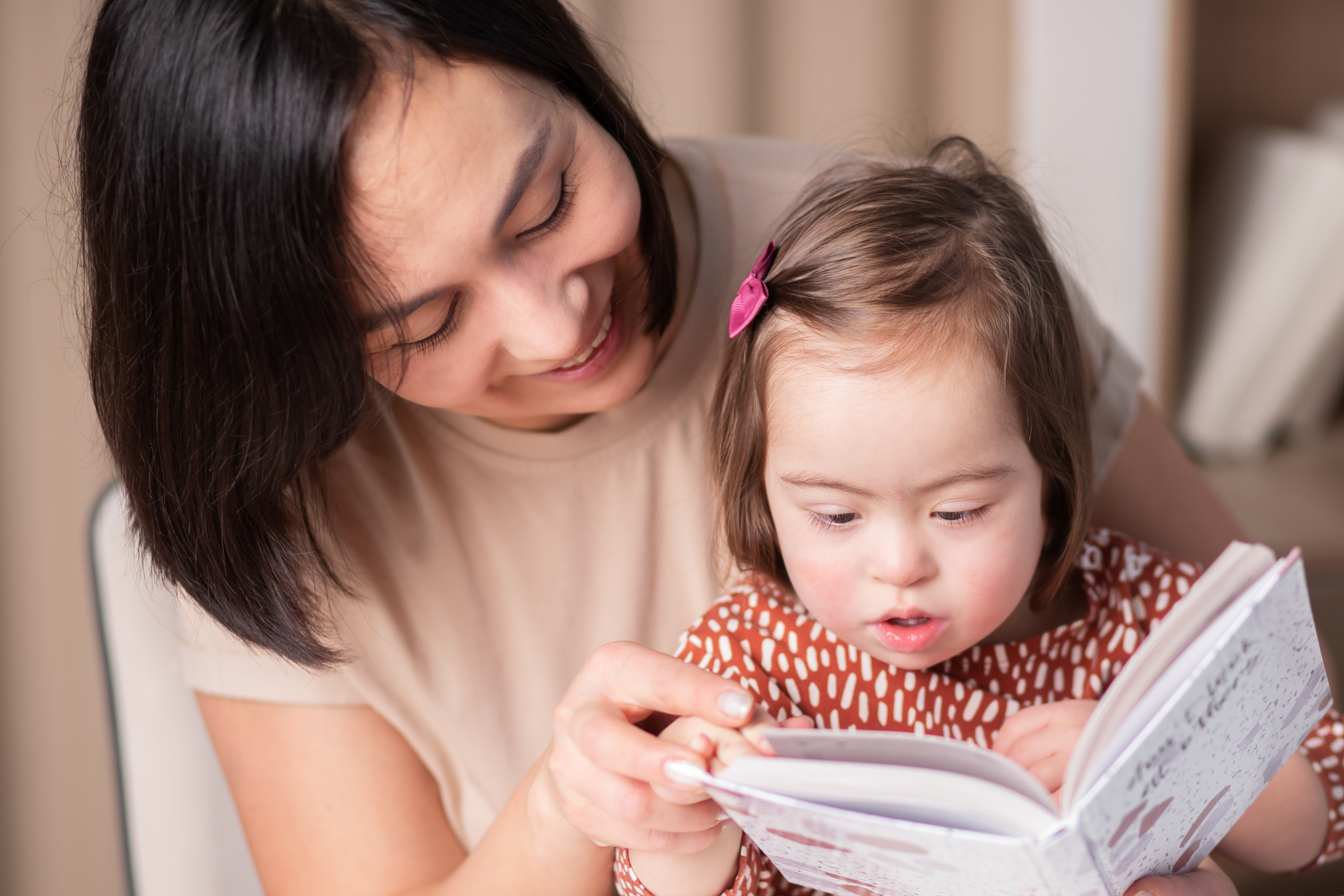 International Down Syndrome Day, March 21, Mother and daughter reading a book