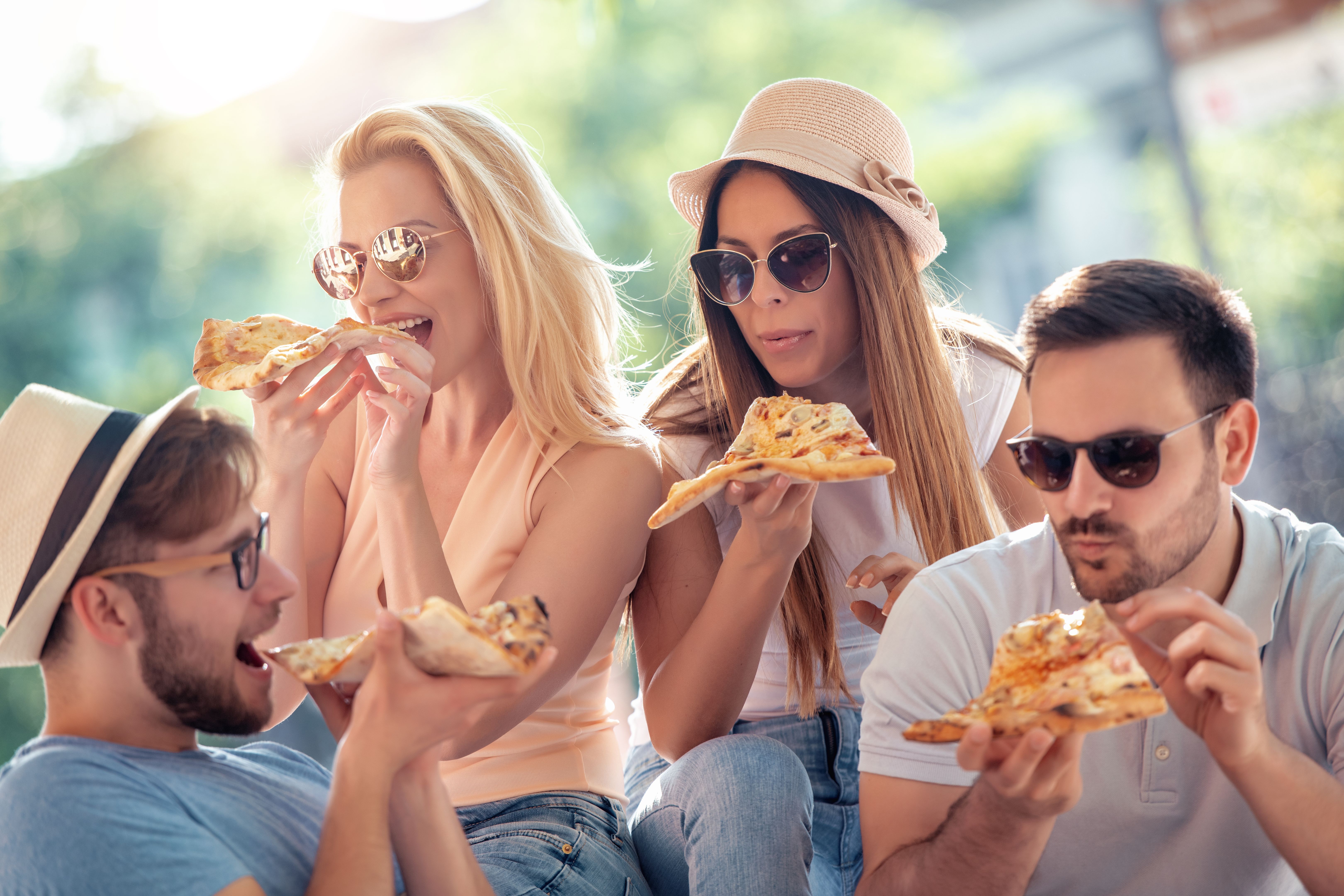 Group of cheerful friends eating pizza