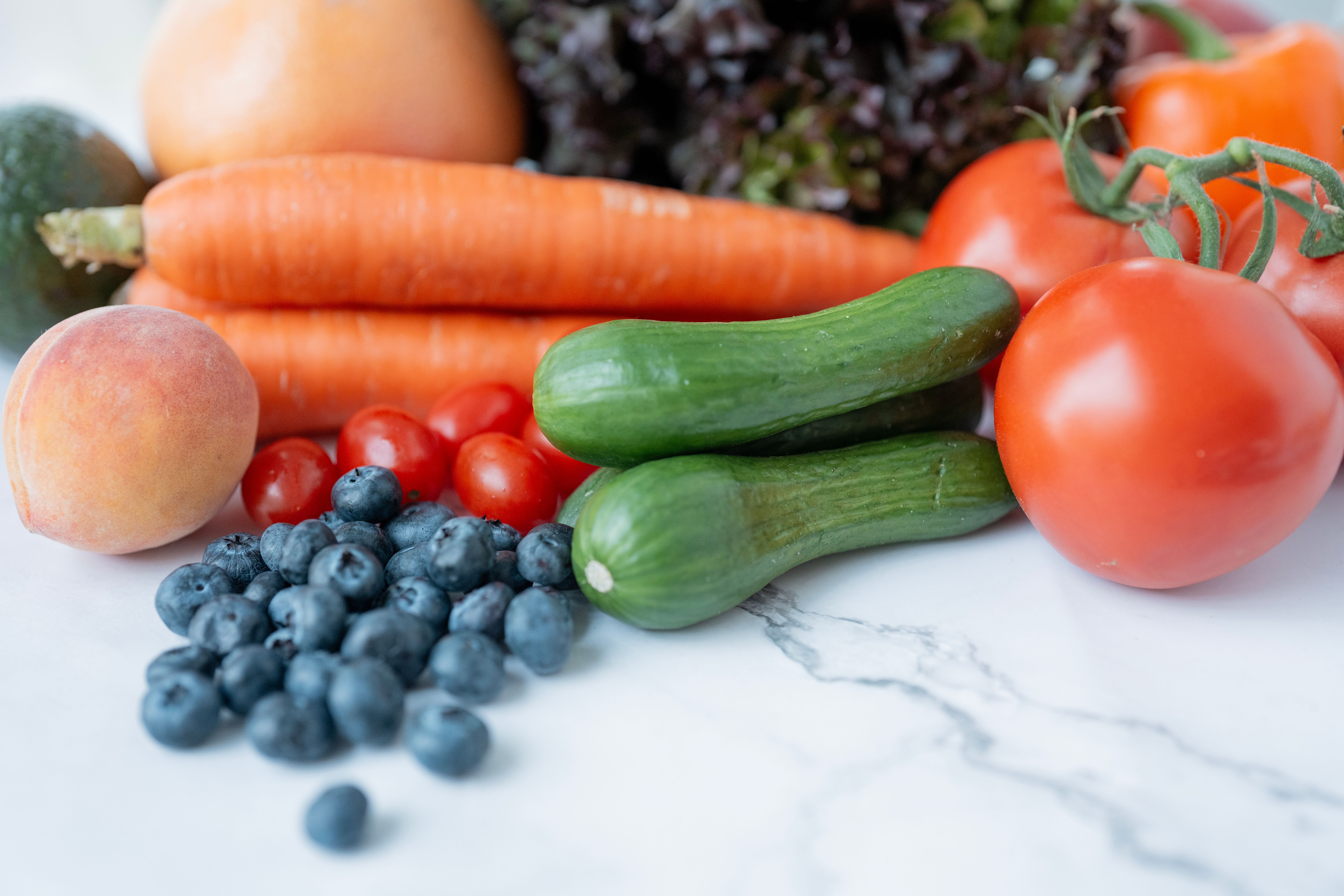 Fresh and Colorful Organic Fruits and Vegetables on Marble Countertop