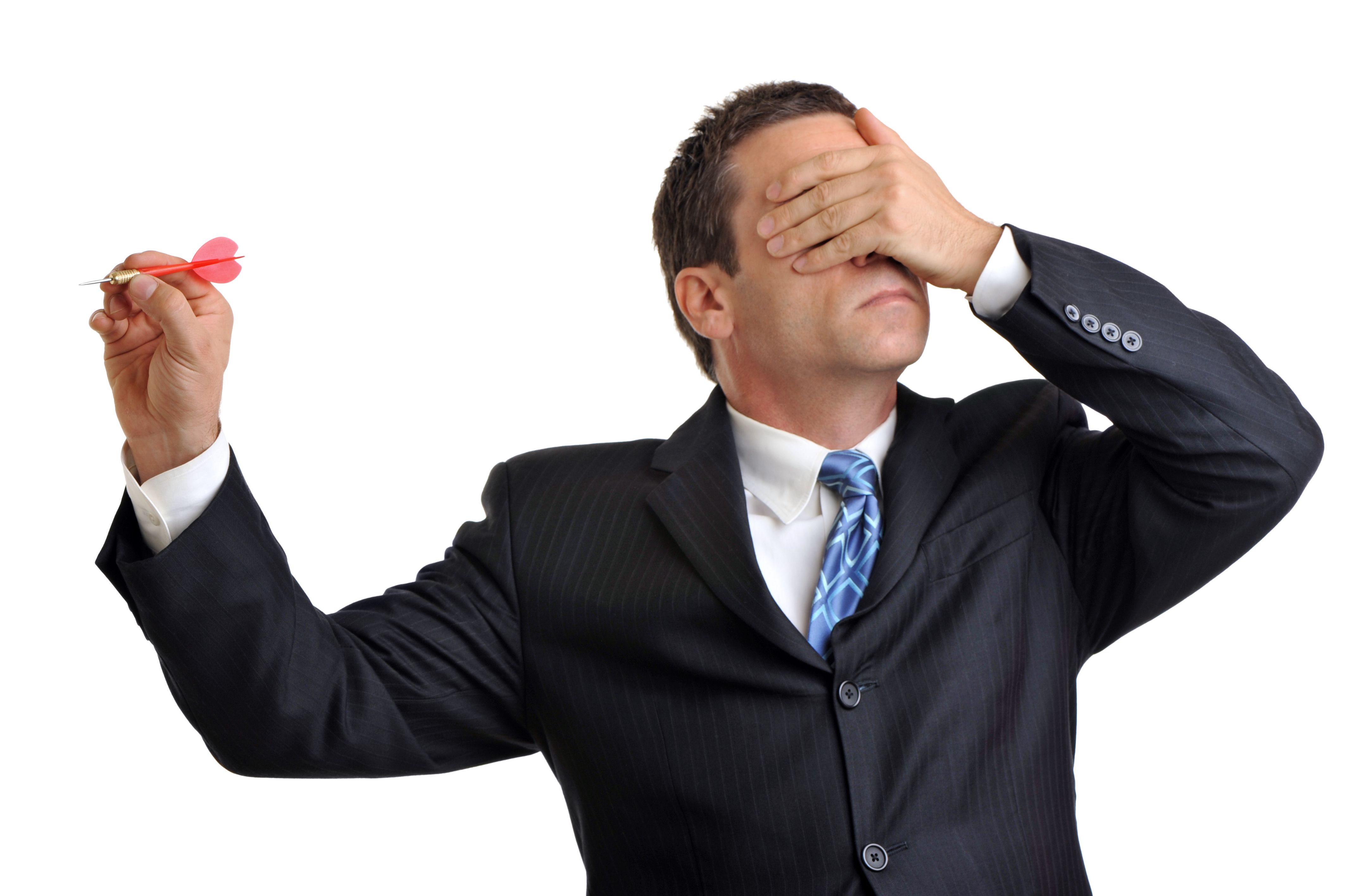 Businessman on white throwing dart with hand over eyes