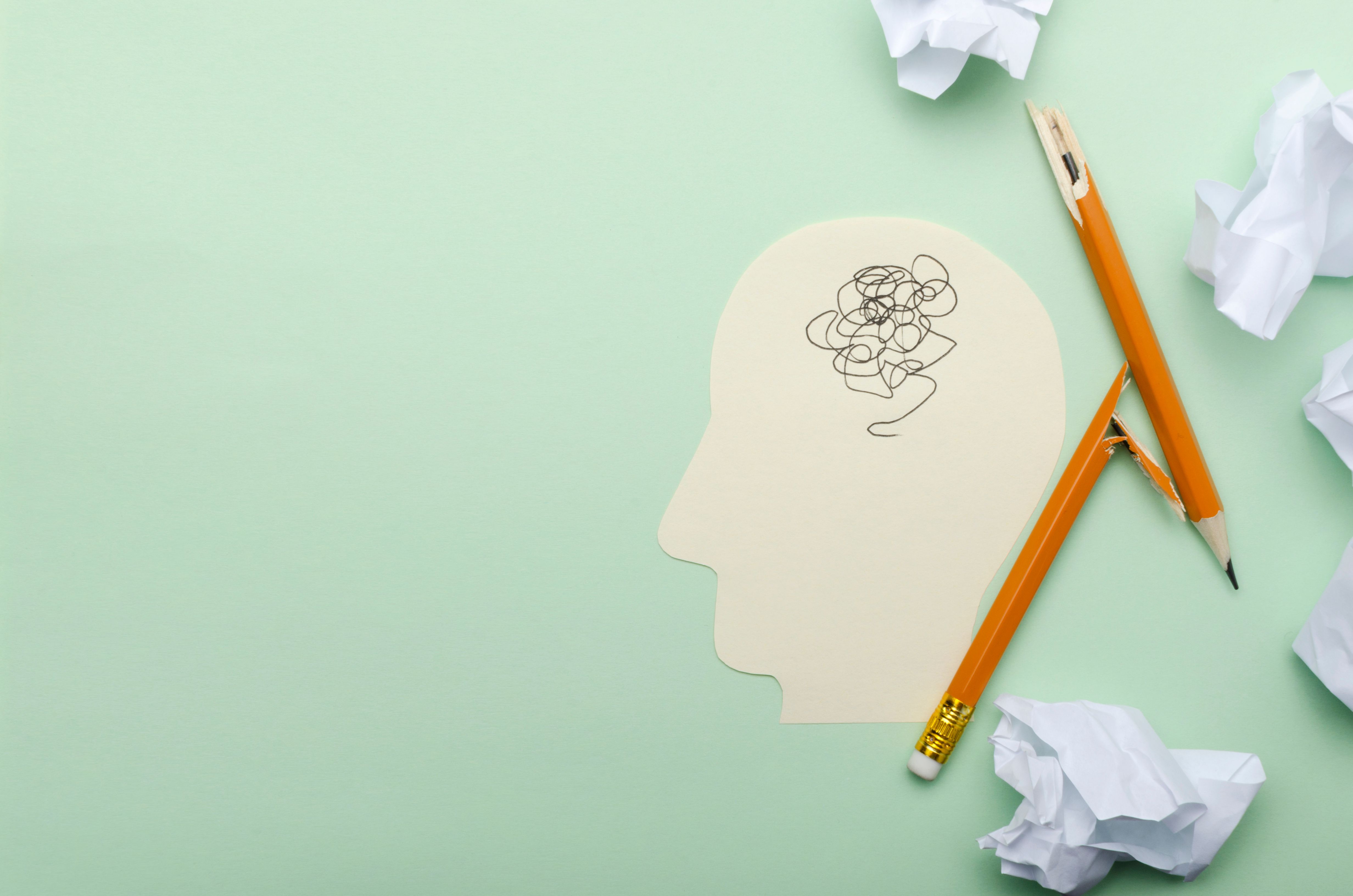 Top view of crumpled paper, broken pencil and paper head as a symbol of reaching a deadlock and stess, mental block.Empty space for text