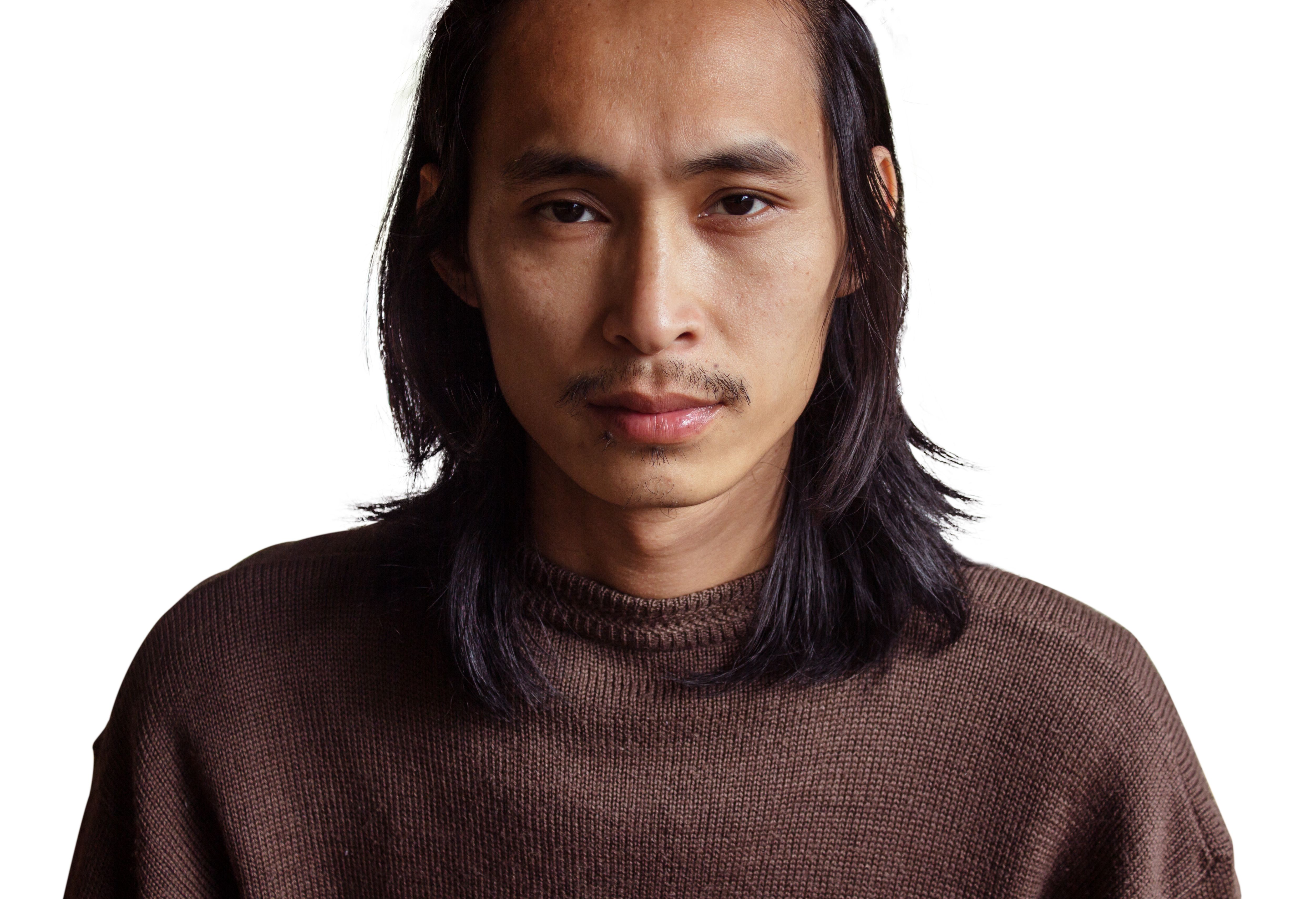 Close-Up Portrait Of Man With Long Hair Against White Background