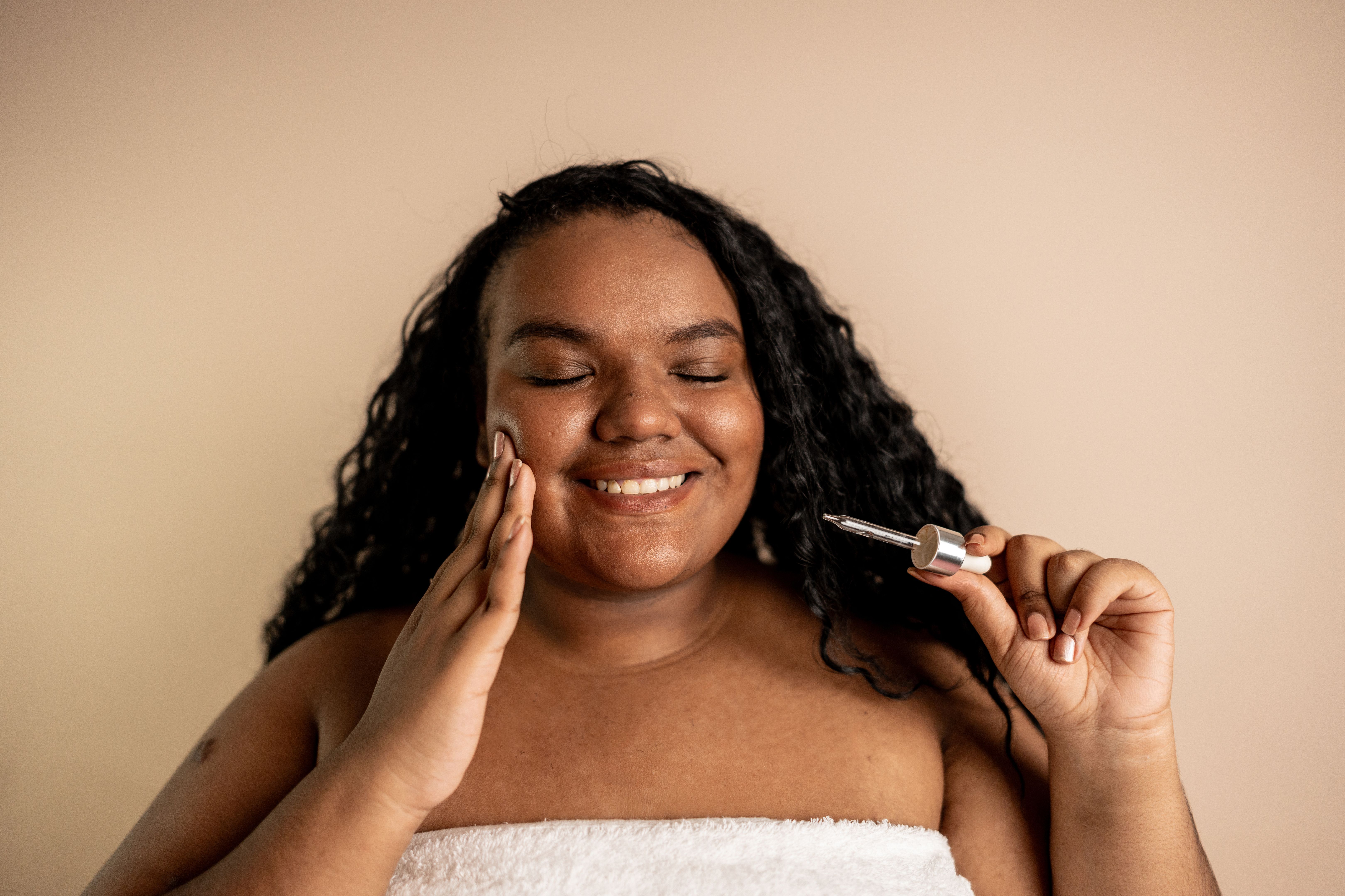 Young woman doing skin care in beige background at studio shot Young woman doing skin care in beige background at studio shot
