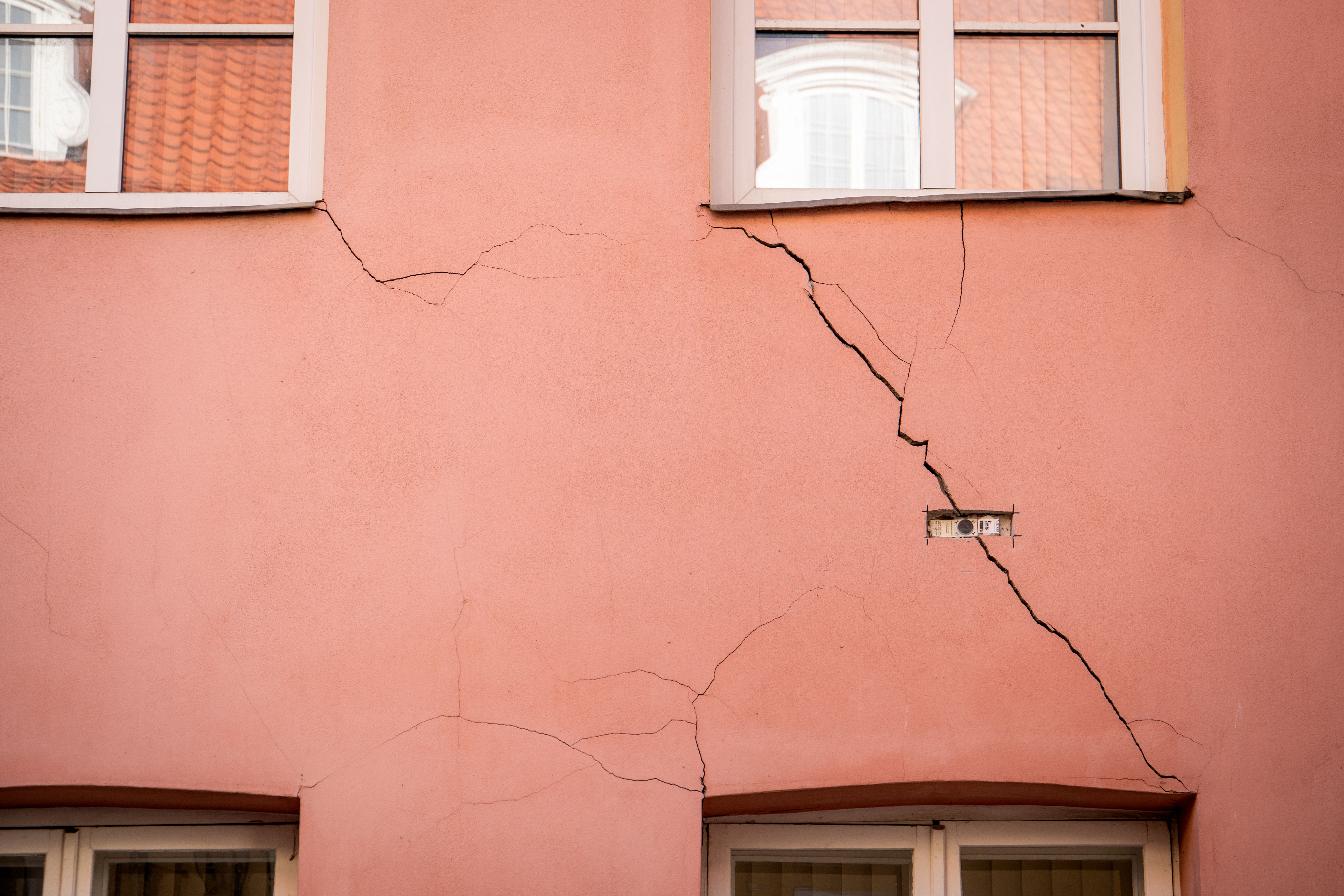 Cracked Wall on Building with Window Reflection