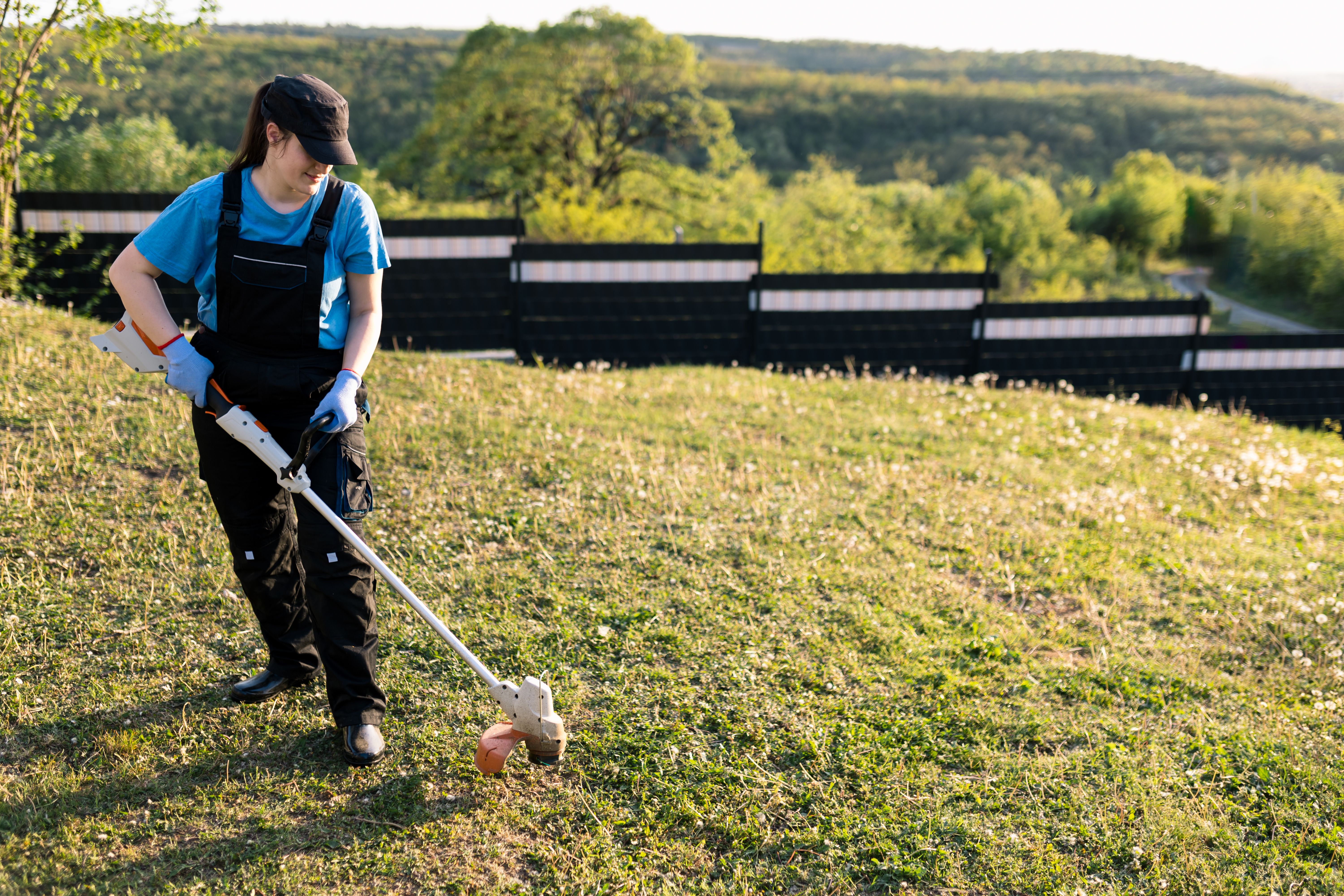 Woman with a weed whacker in outdoors