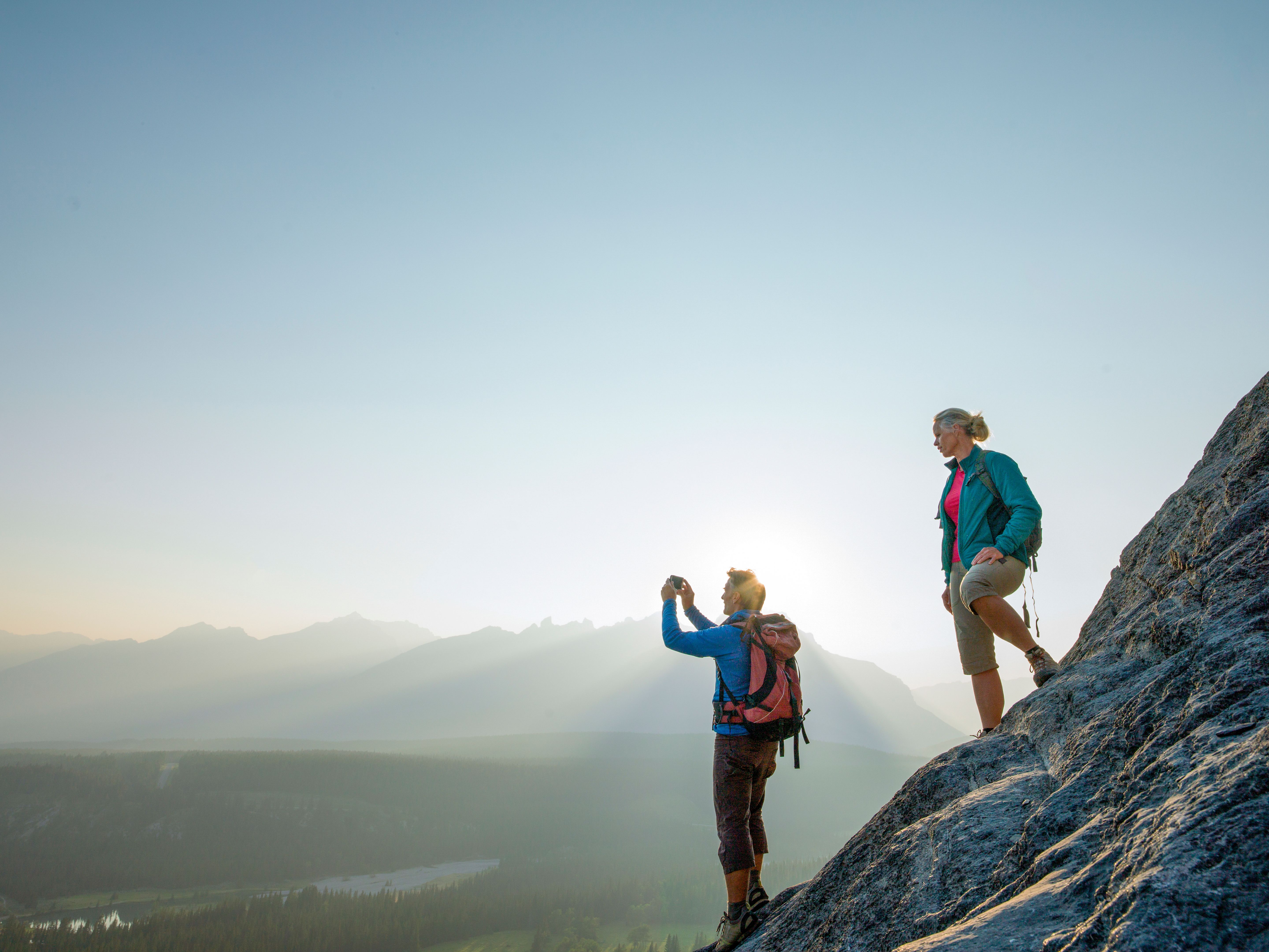 Couple pause on mountain ridge and take photo Couple pause on mountain ridge and take photo