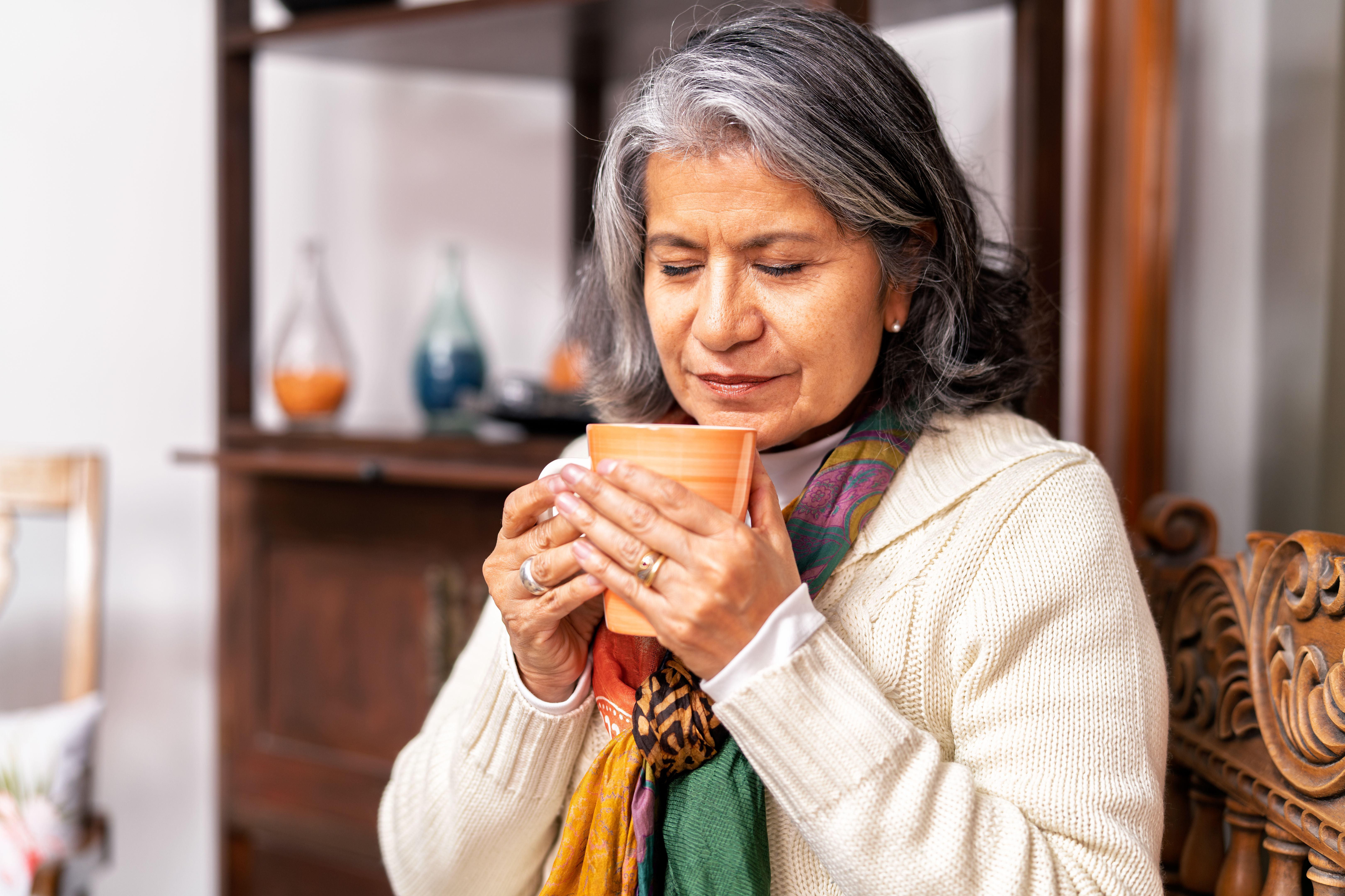 Senior woman enjoying a warm cup of tea at home