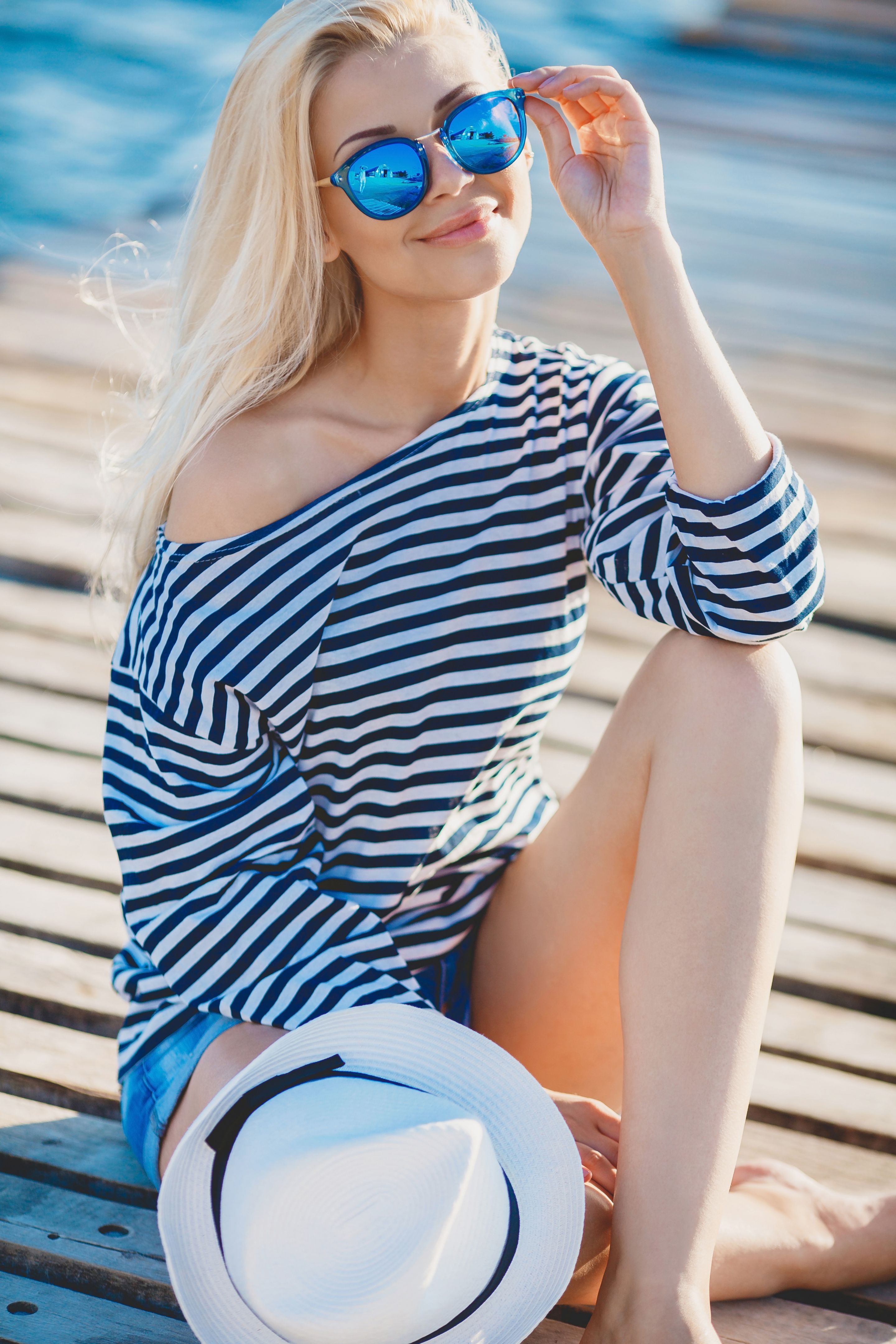 Young blonde in vest on pier