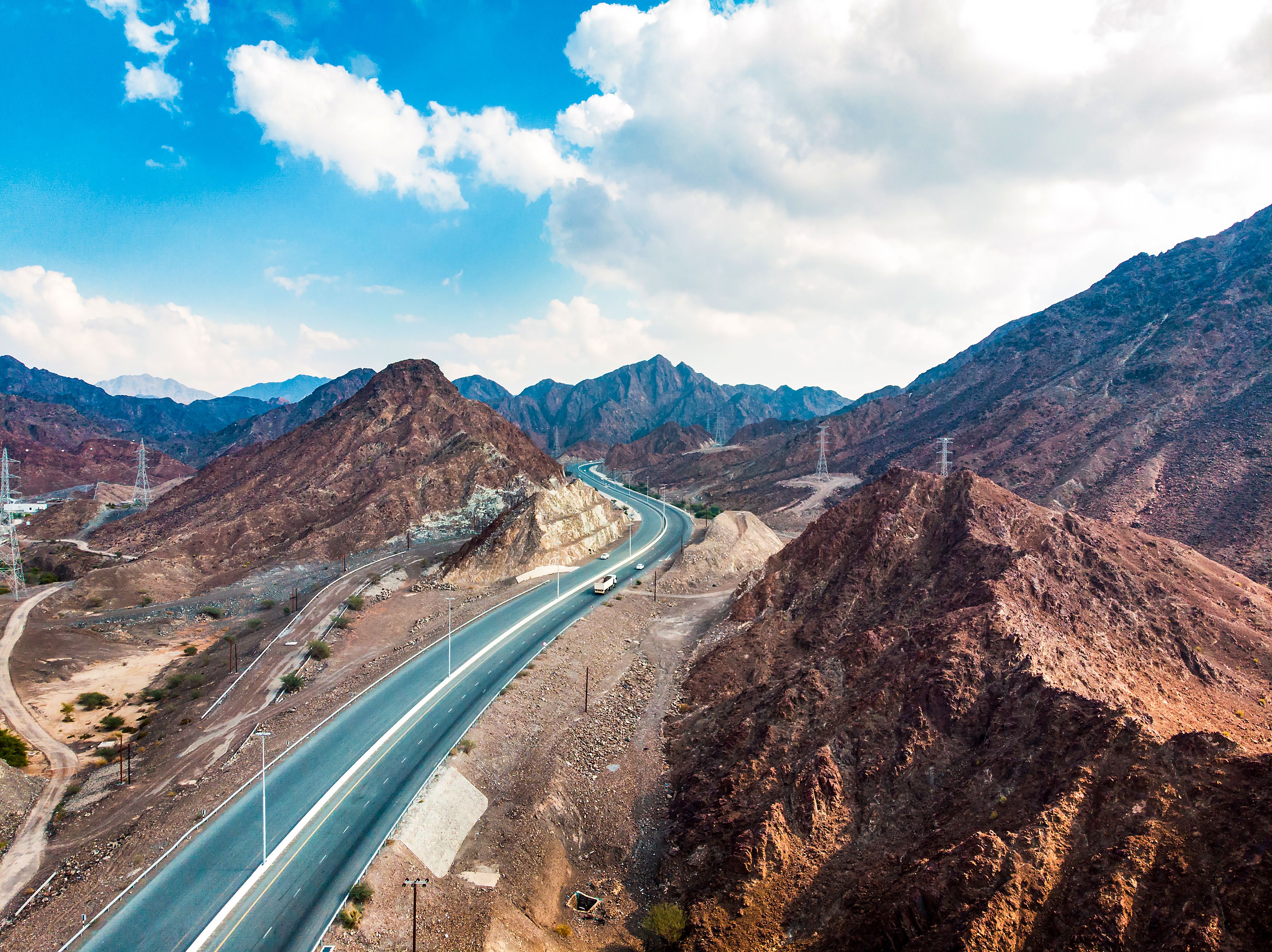 Desert road through Hajar mountain range stretching through UAE