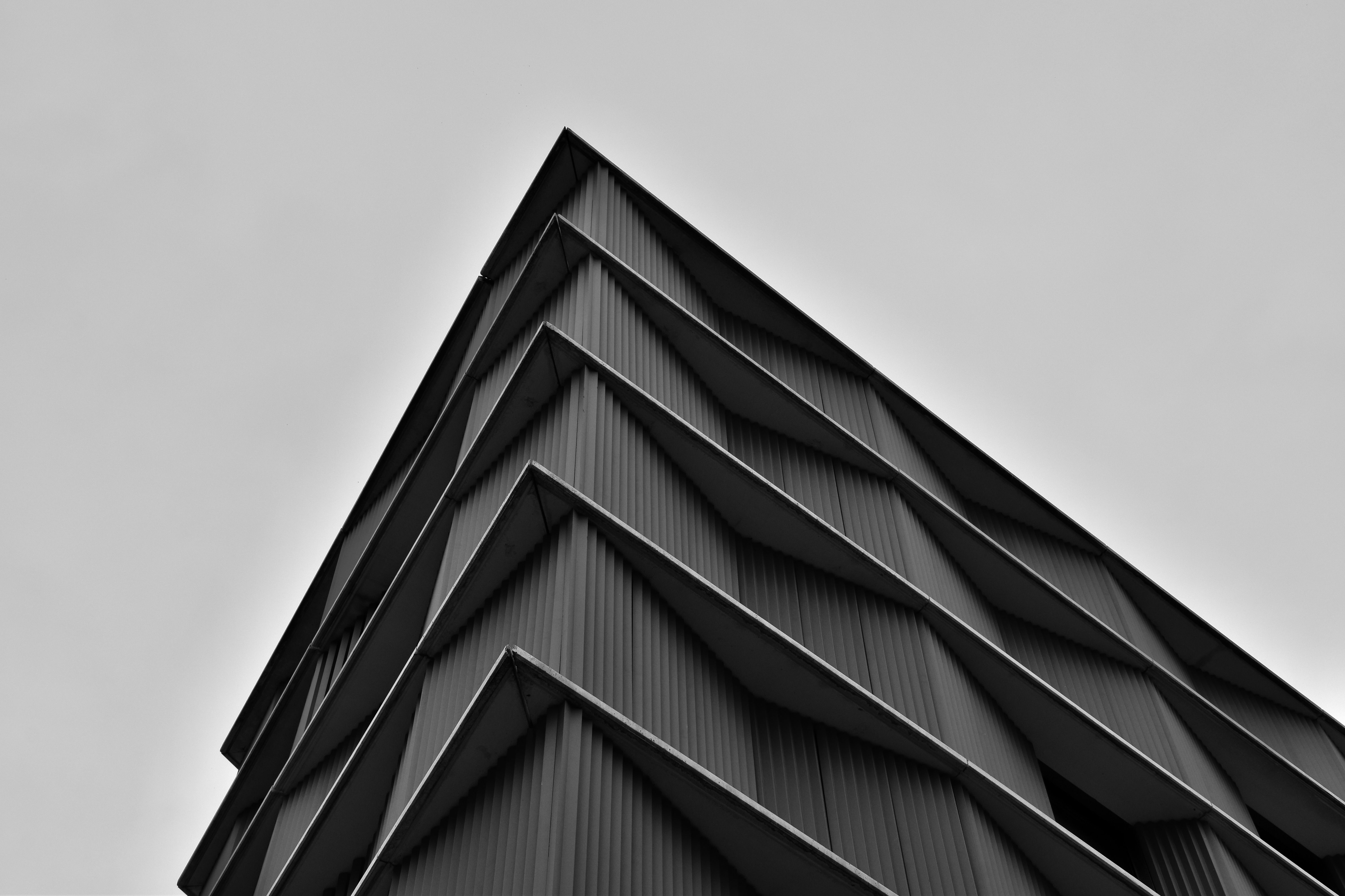 corner of a modern triangular building in black and white