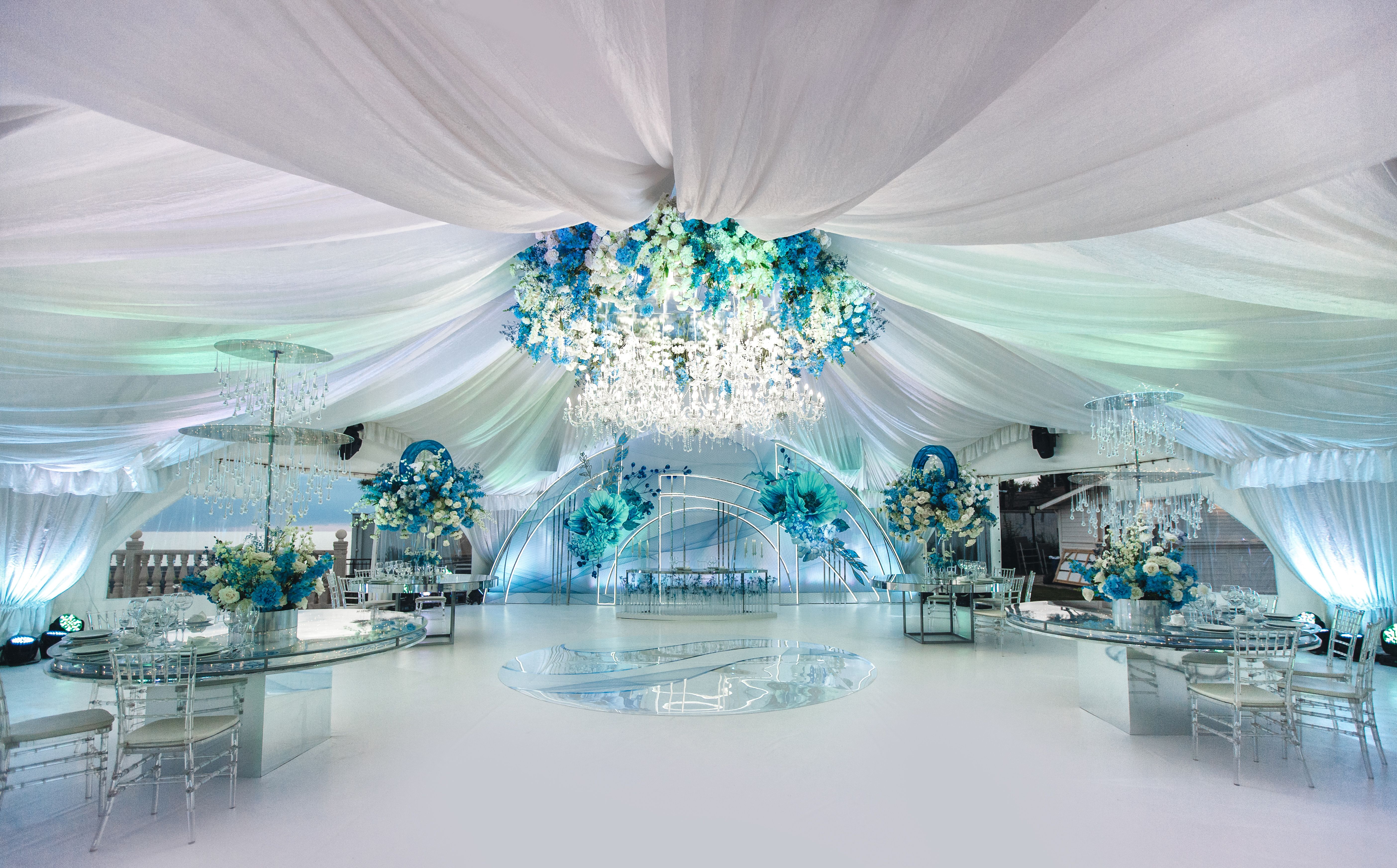 Wedding ceremony in a beautiful tent. Hall with dining tables decorated with bouquets of flowers. Wedding ceremony in a beautiful tent. Hall with dining tables decorated with bouquets of flowers.