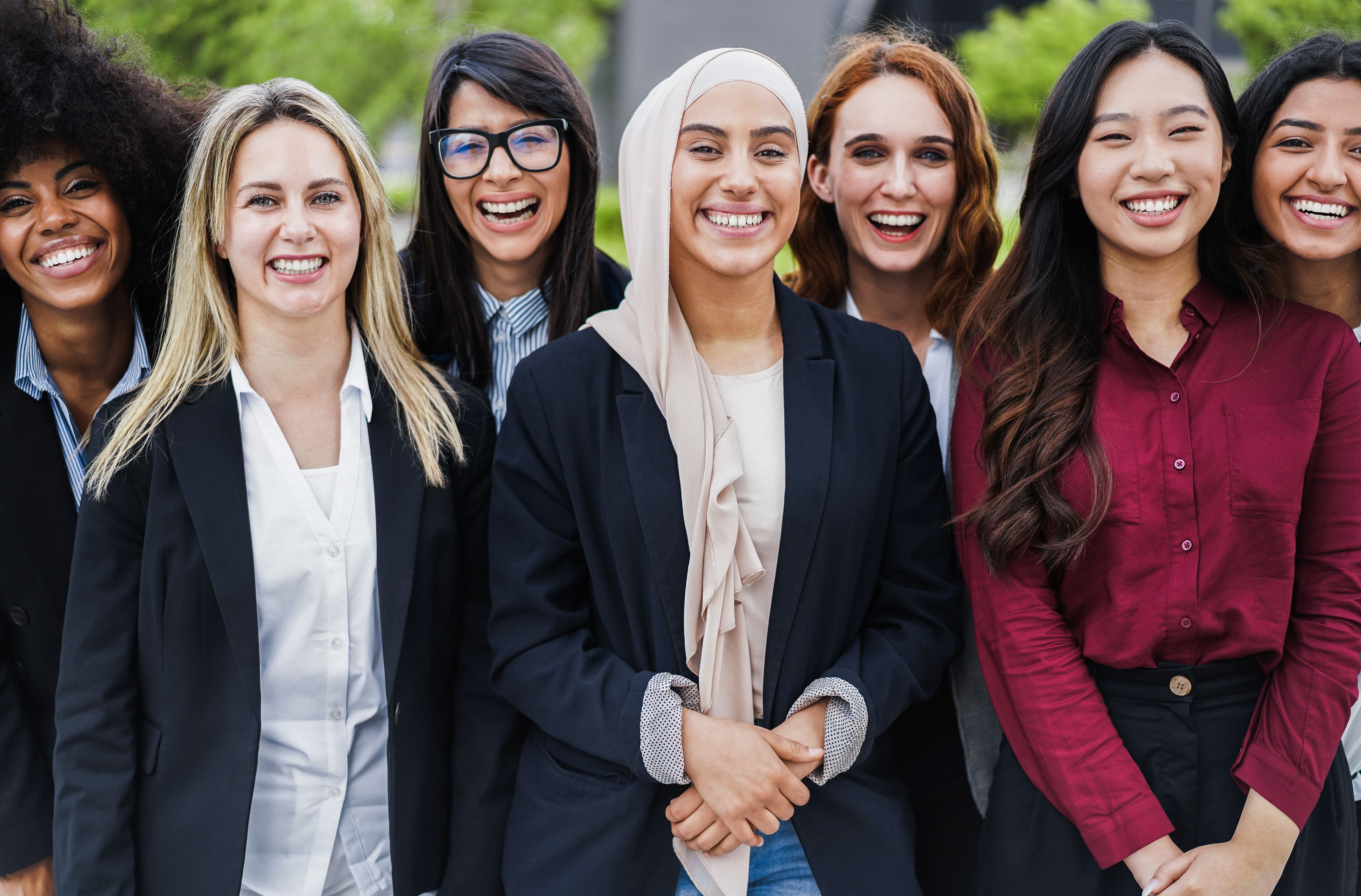 Multiethnic business female colleagues smiling on camera outdoor - Focus on muslim girl face