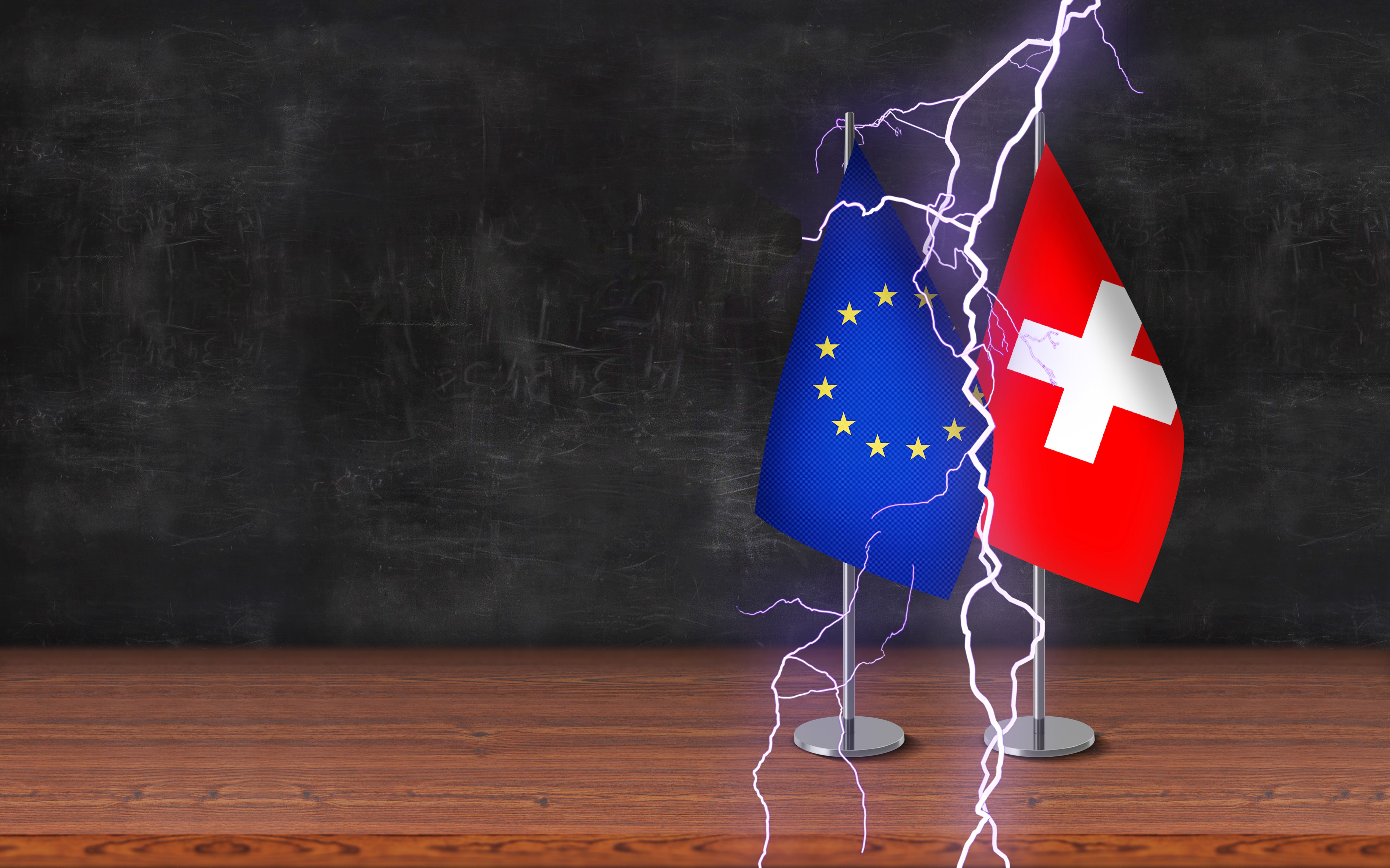 Conflict between countries concept; european union and switzerland 3D desk flags with thunder are standing together on a desk and in front of blackboard background with large copy space. Conflict between countries concept; european union and switzerland 3D desk flags with thunder are standing together on a desk and in front of blackboard background with large copy space.