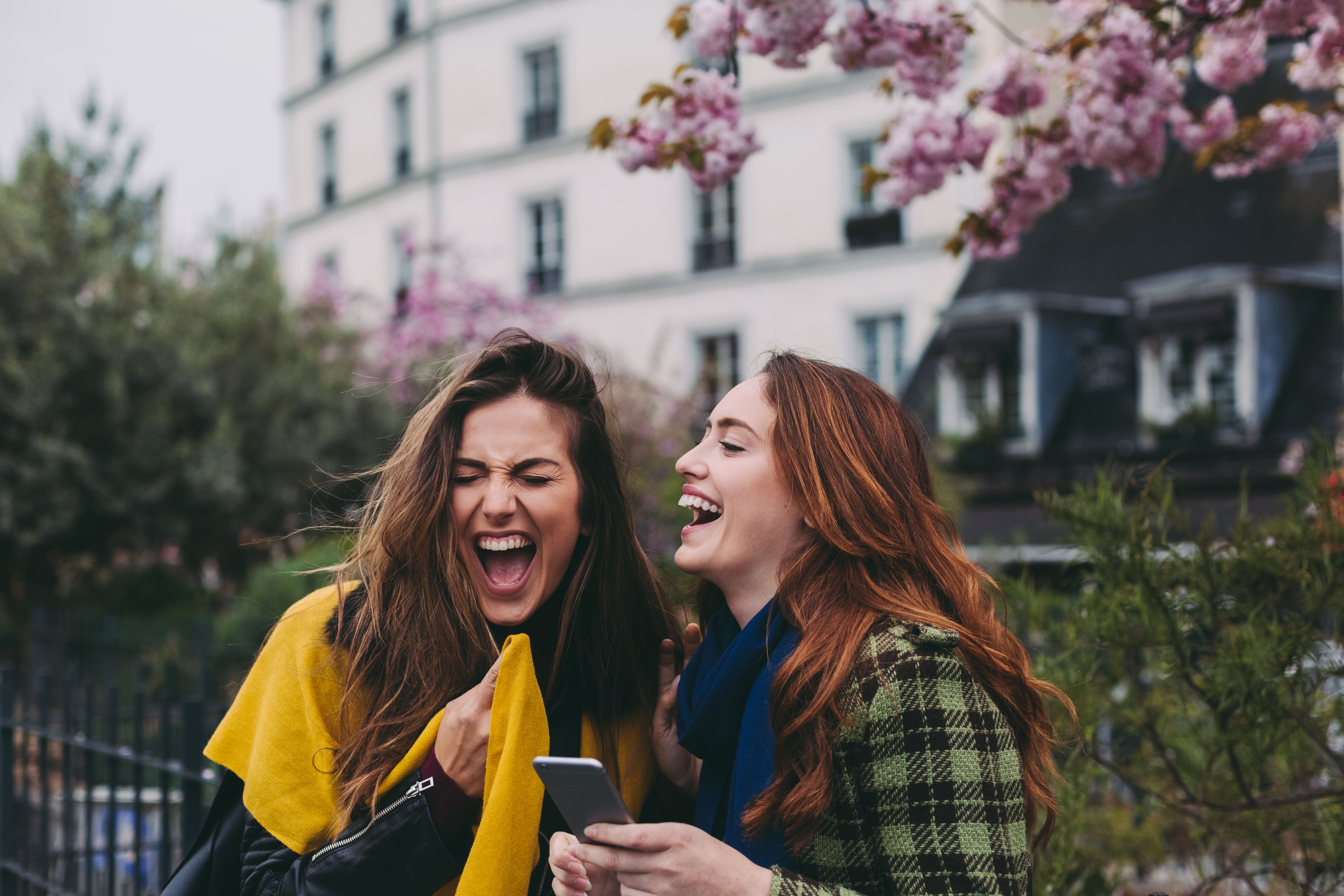 Best friends in Paris laughing and texting