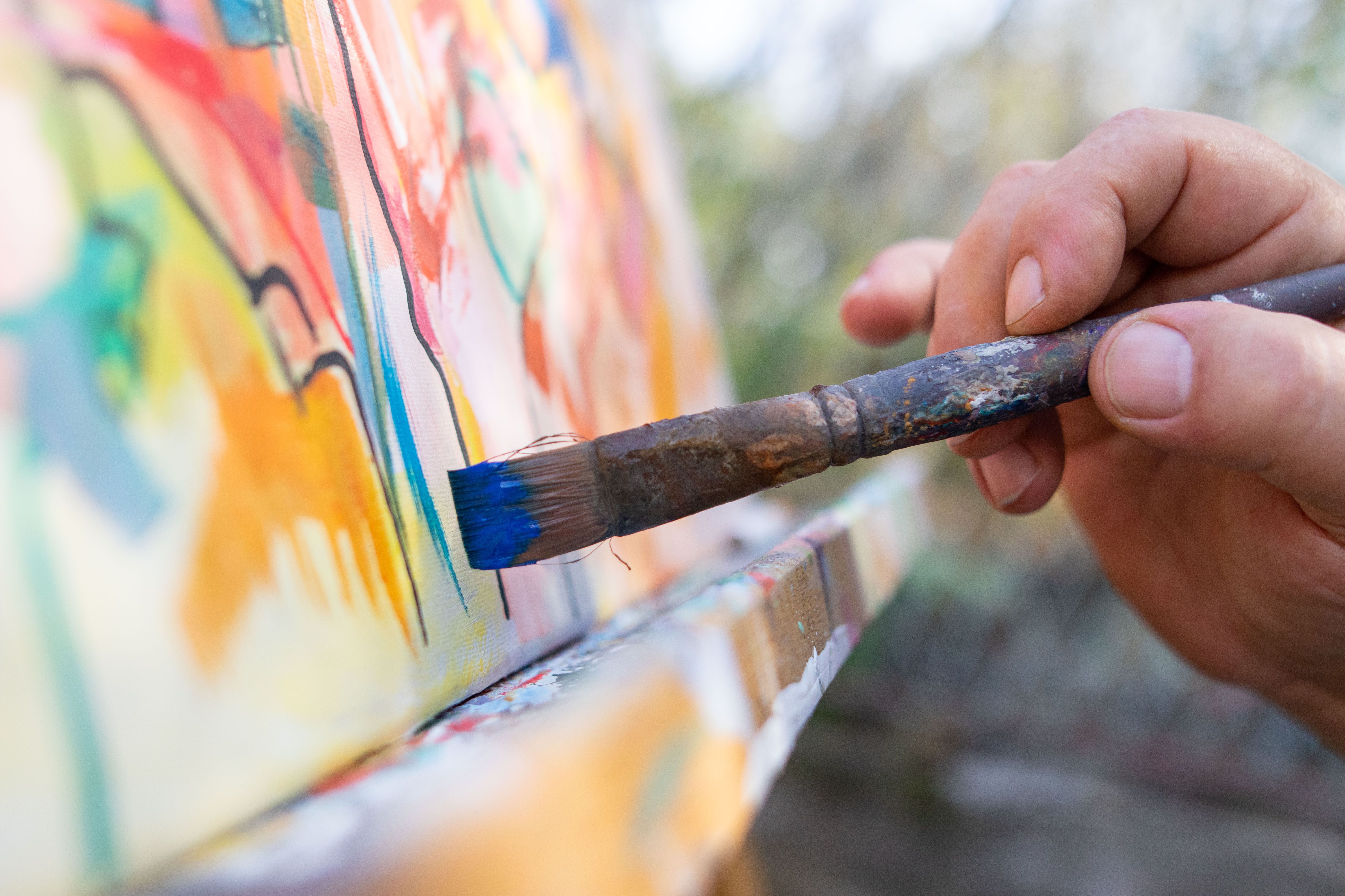 Close-up of an artist- painter working on painting in studio