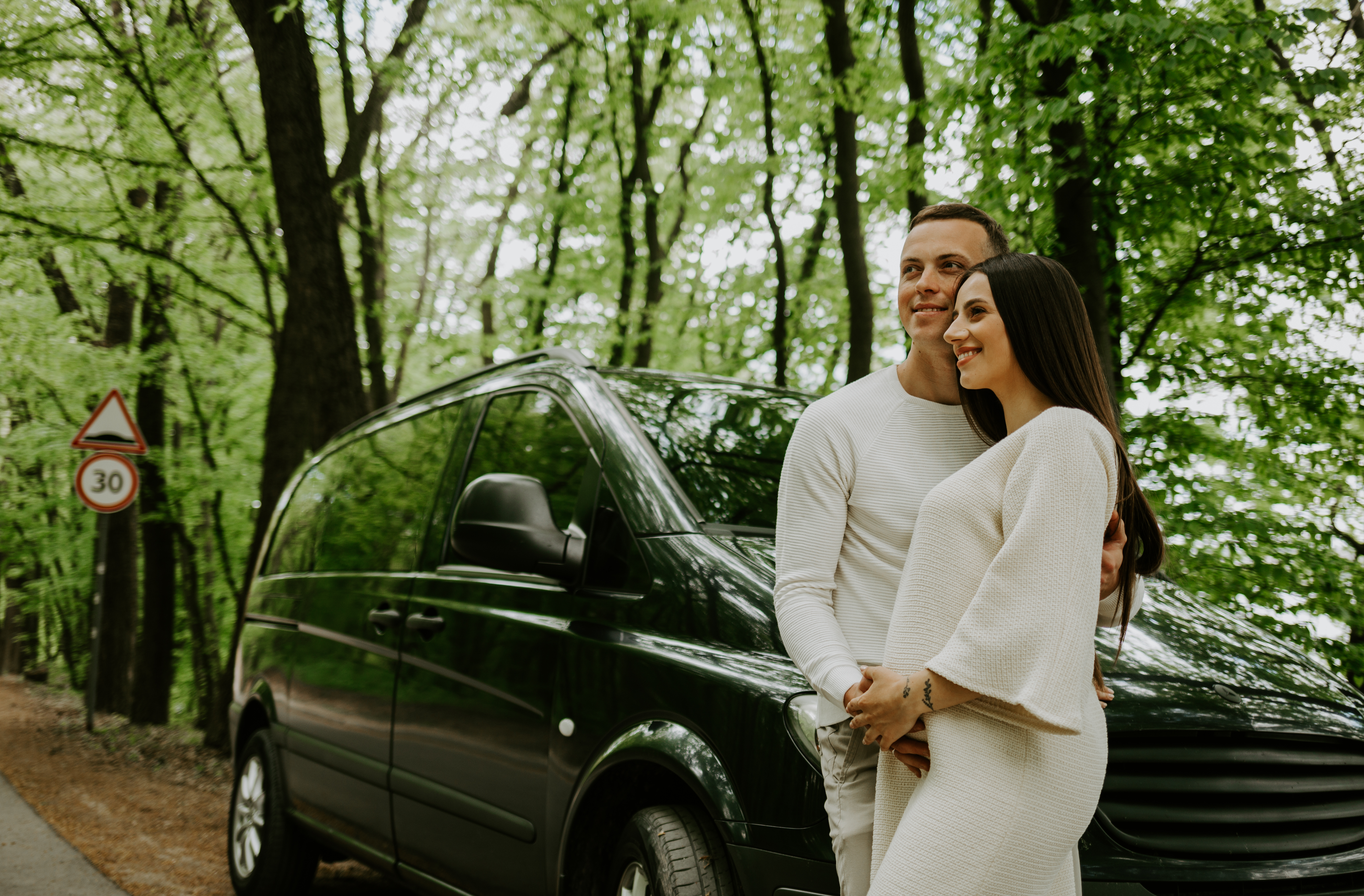 Young pregnant woman with her husband enjoying the nature. Traveling on family car in the field. Young pregnant woman with her husband enjoying the nature. Traveling on family car in the field.