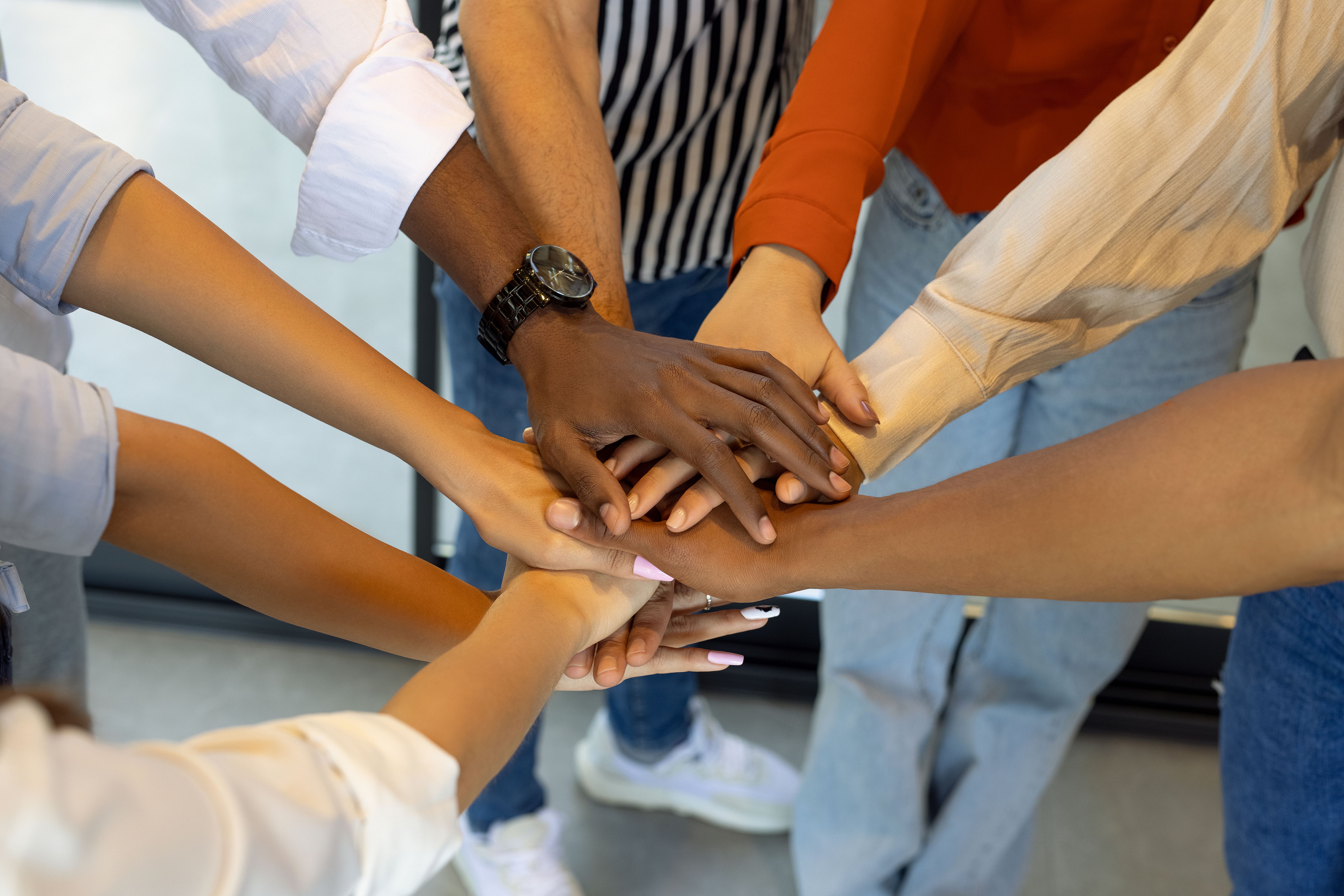 Unrecognizable business team holding their hands together