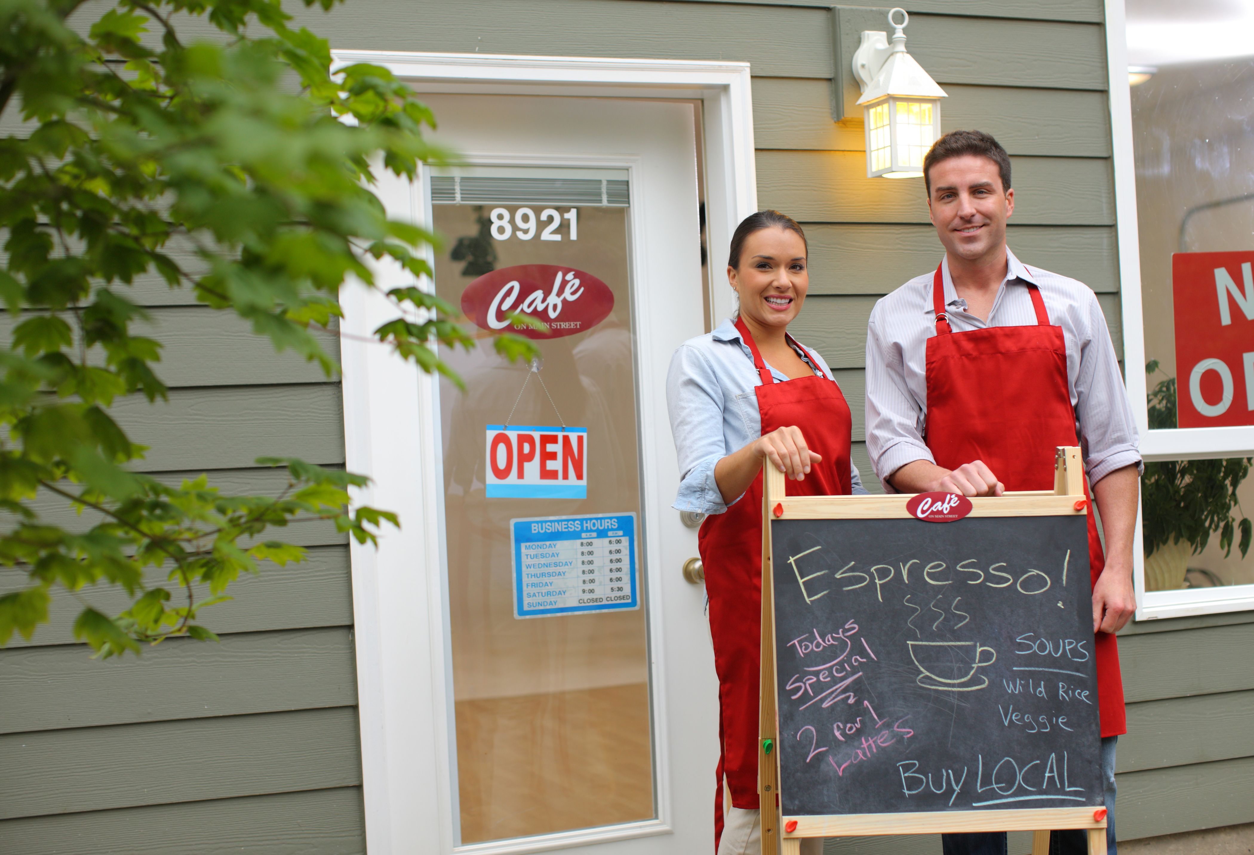 Small business owners standing in front of cafe