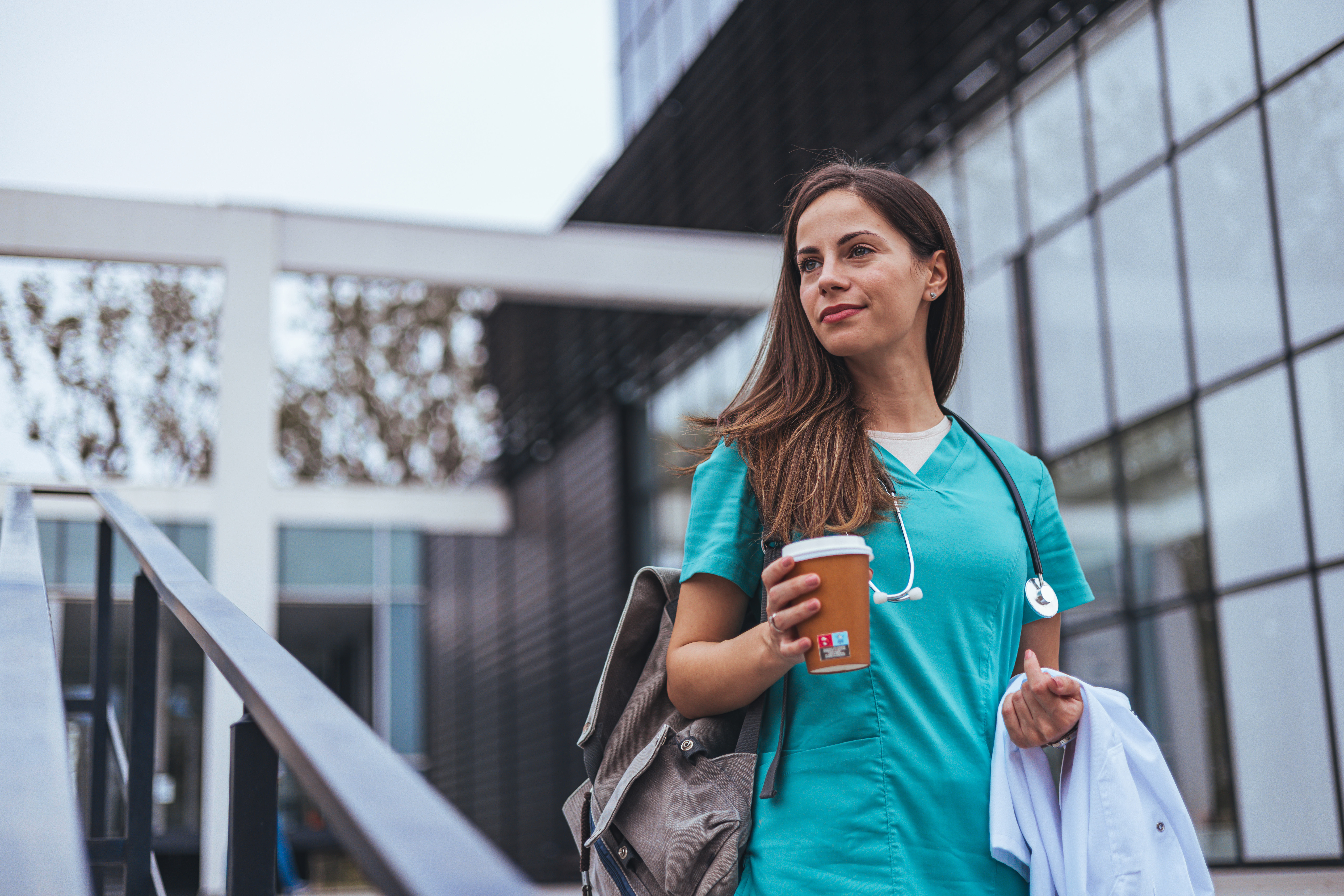 Smiling female surgeon standing outdoors while looking away.