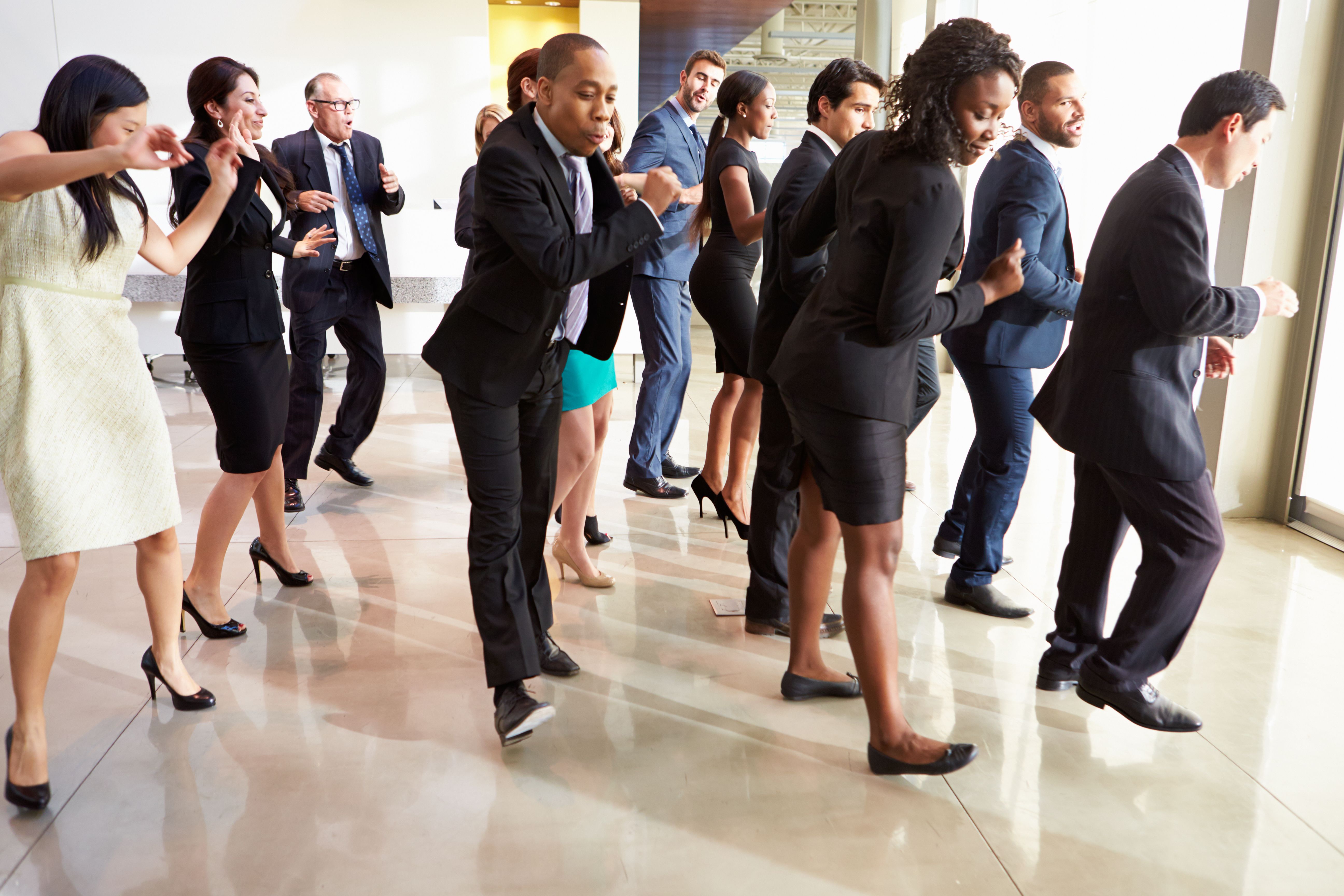 Businessmen And Businesswomen Dancing In Office Lobby Businessmen And Businesswomen Dancing In Office Lobby