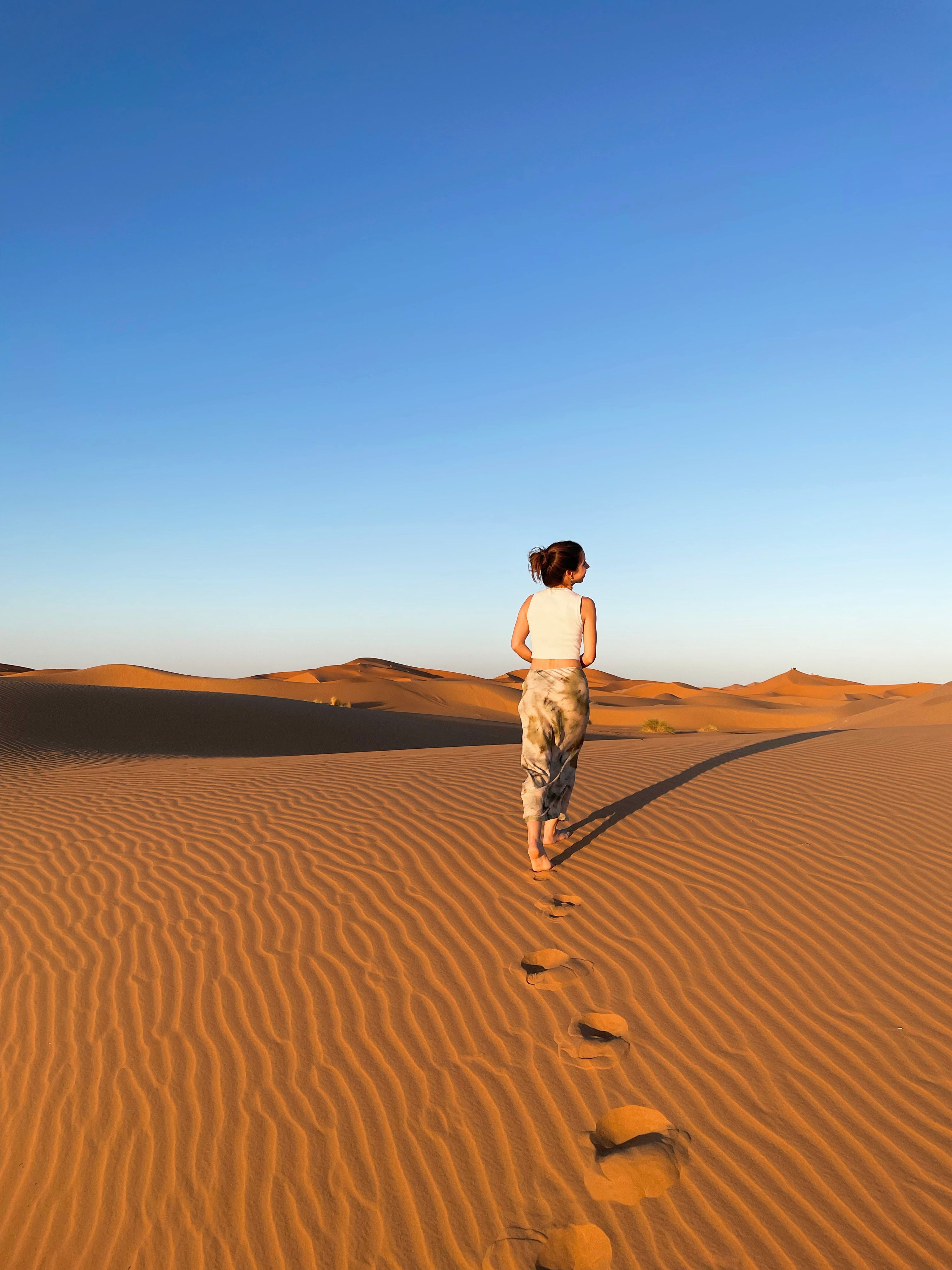fille marchant à travers les dunes de sable du désert du Sahara à Merzouga. Voyage en solo
