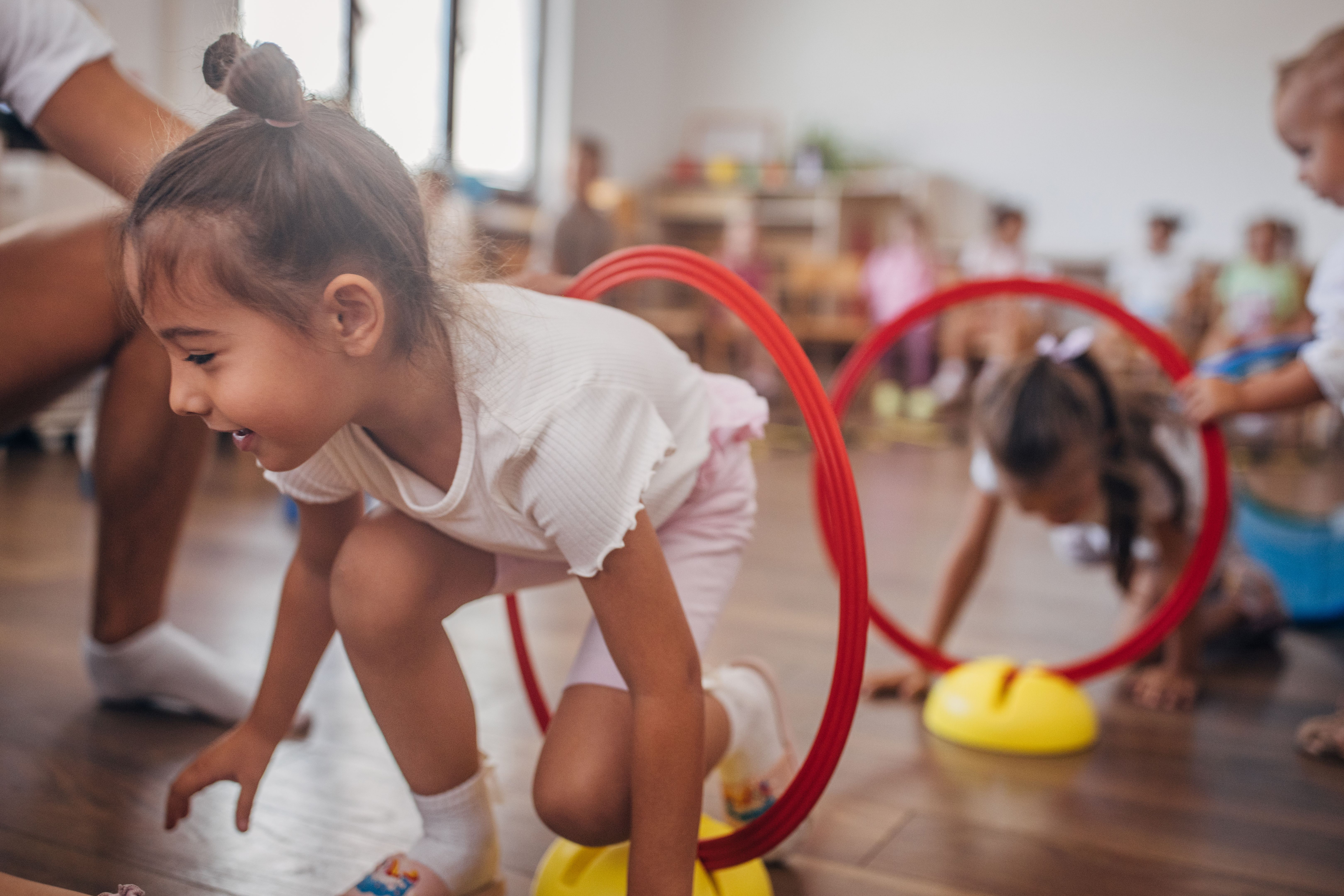 Girl jumping through red hoops during a classroom game