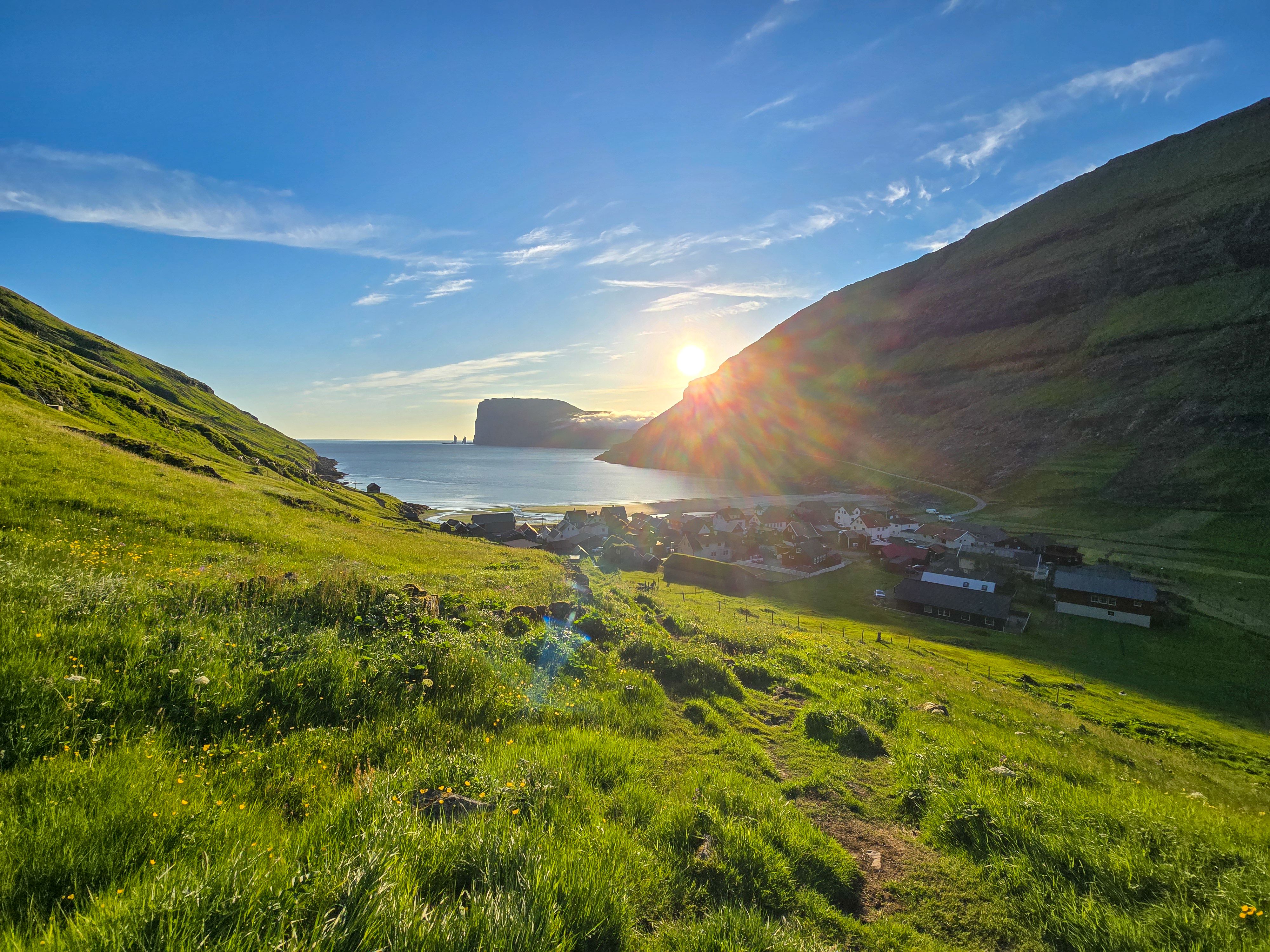 Breathtaking sunset over the tranquil village in the Faroe Islands surrounded by lush hills