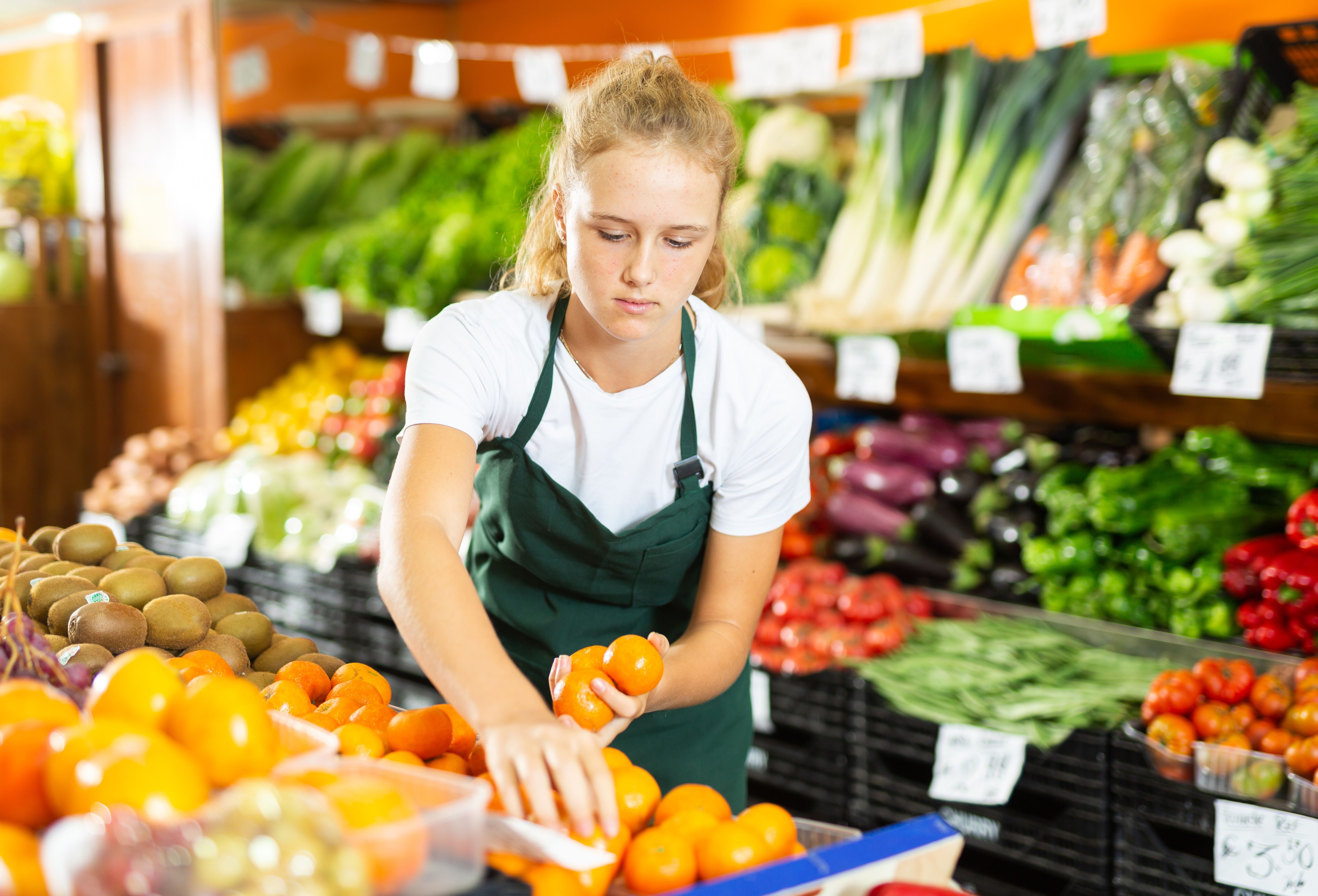 Girl at her first job in vegetable shop