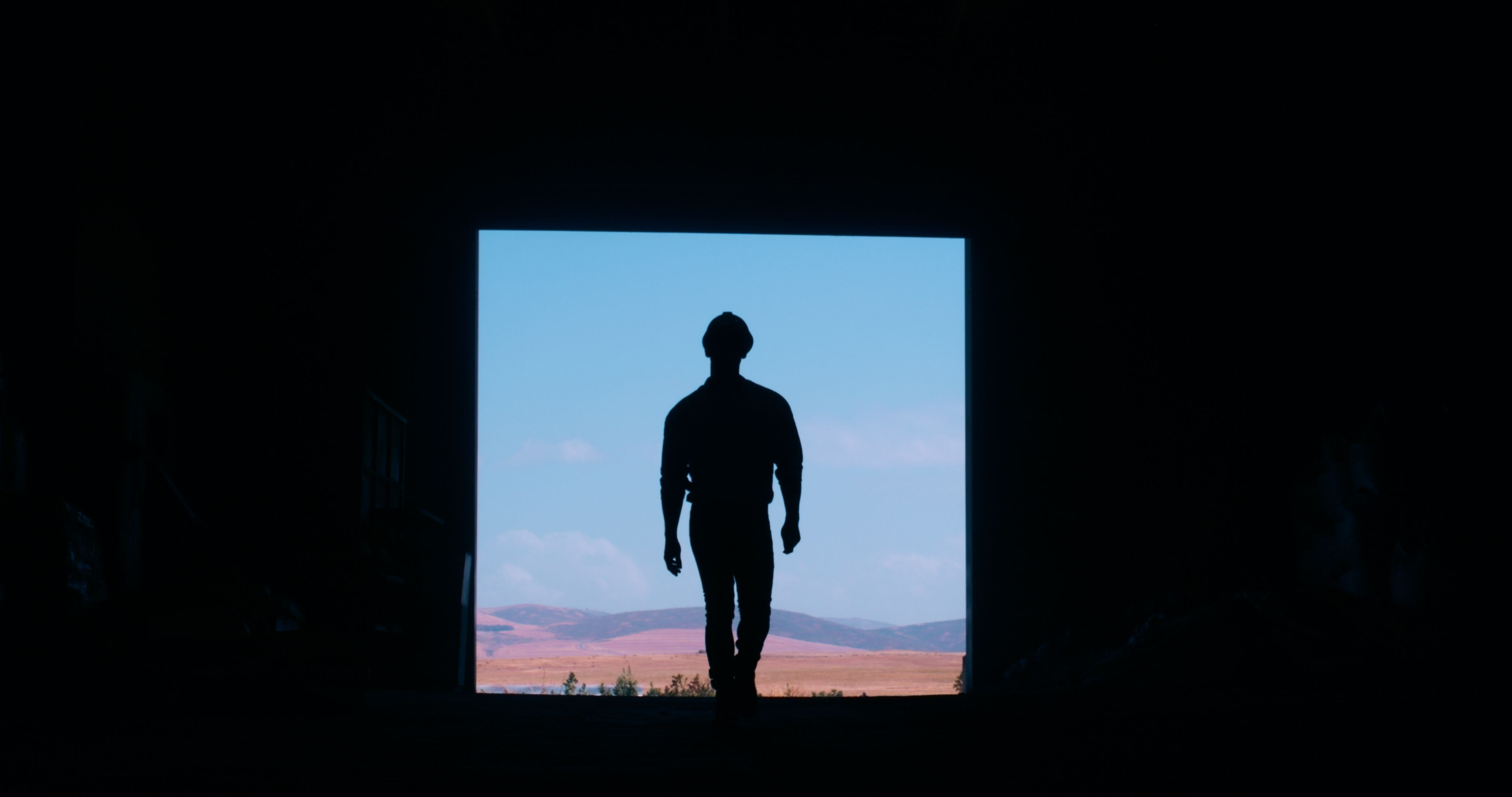 Silhouette, construction worker and back view of person on site, mockup space and maintenance labor. Architecture, engineer and black frame with contractor for renovation project or infrastructure