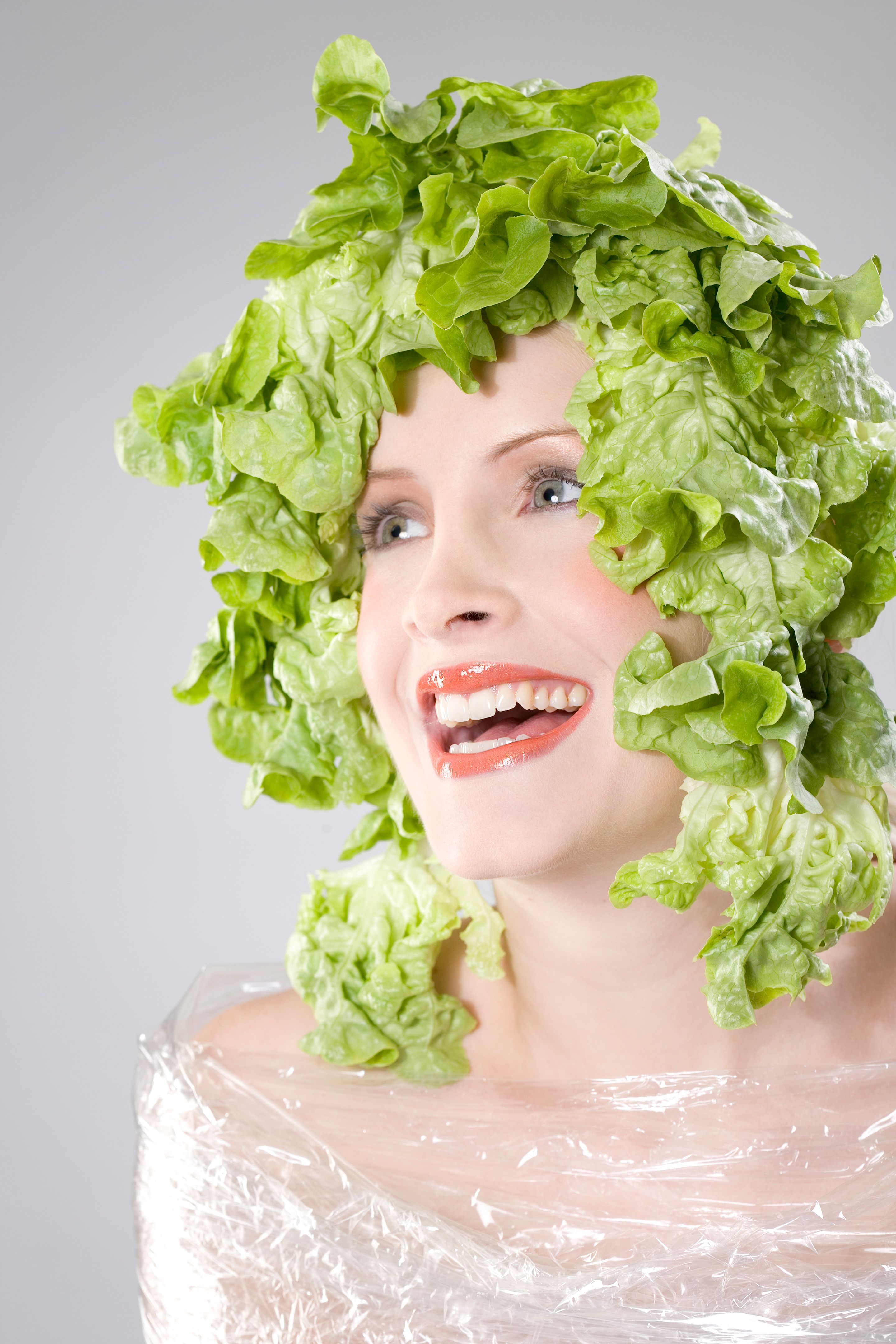 Young woman with lettuce on head, portrait