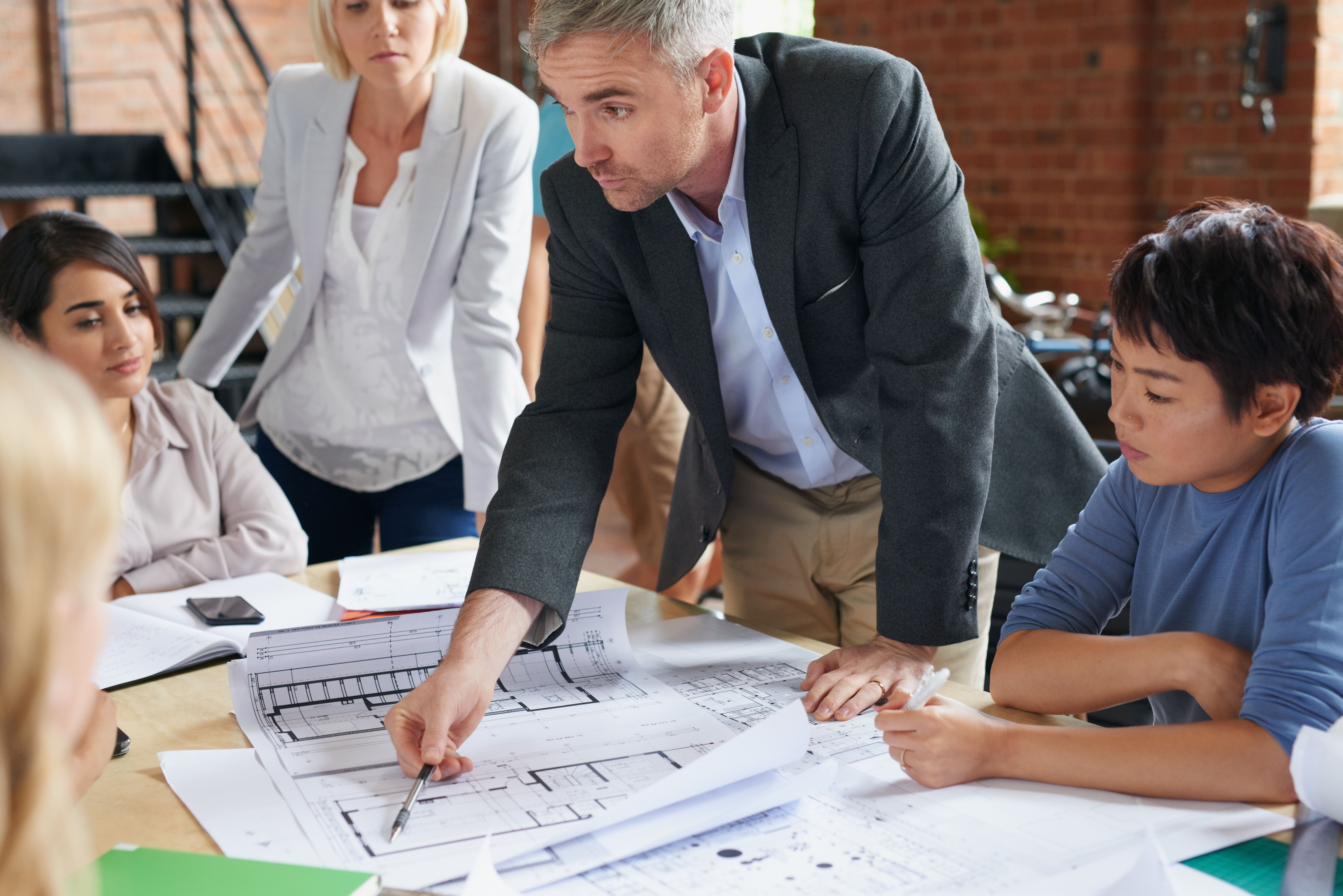 Shot of a group of architects working with blueprints in an office