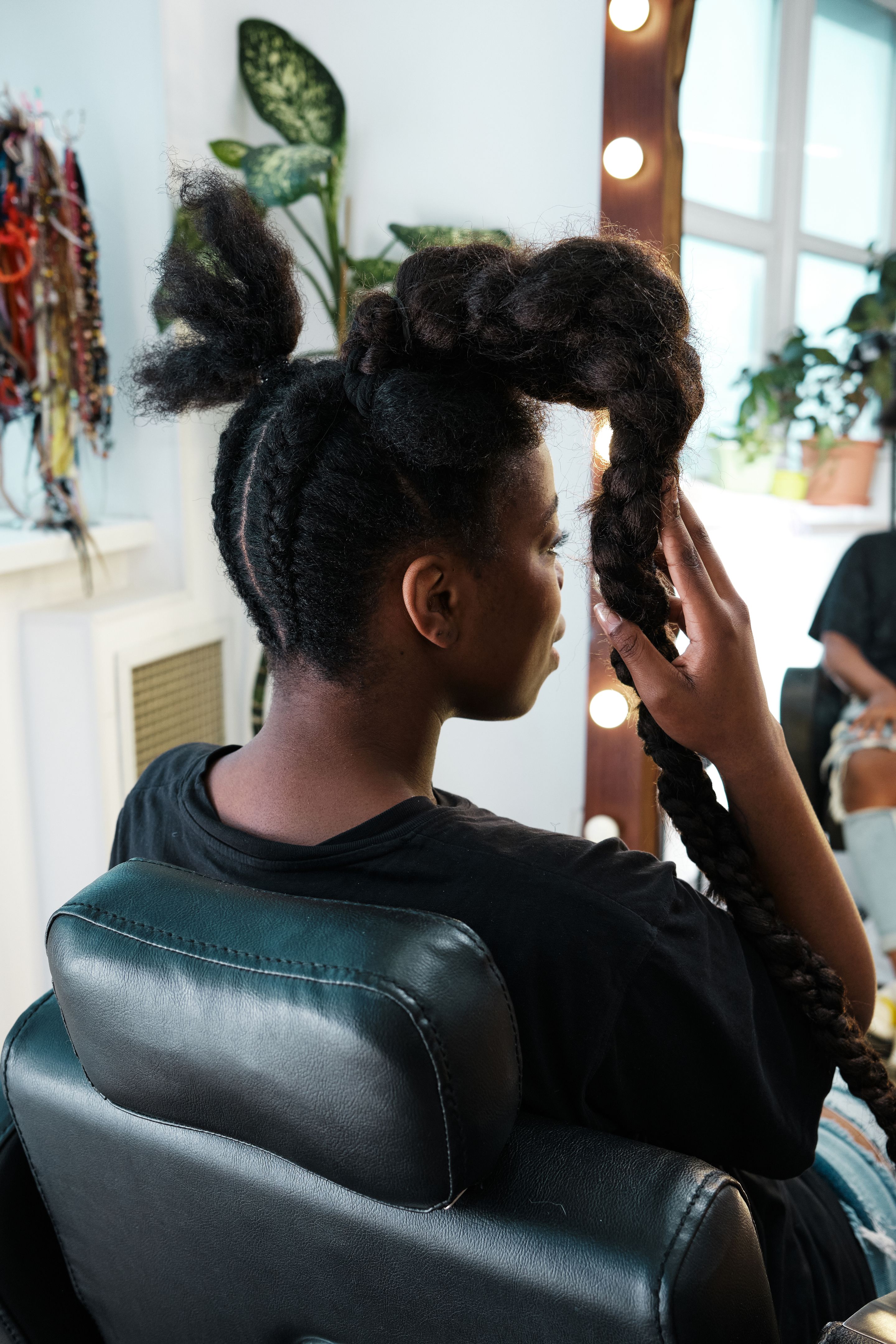 African woman in a beauty salon in the process of creating a creative hairstyle