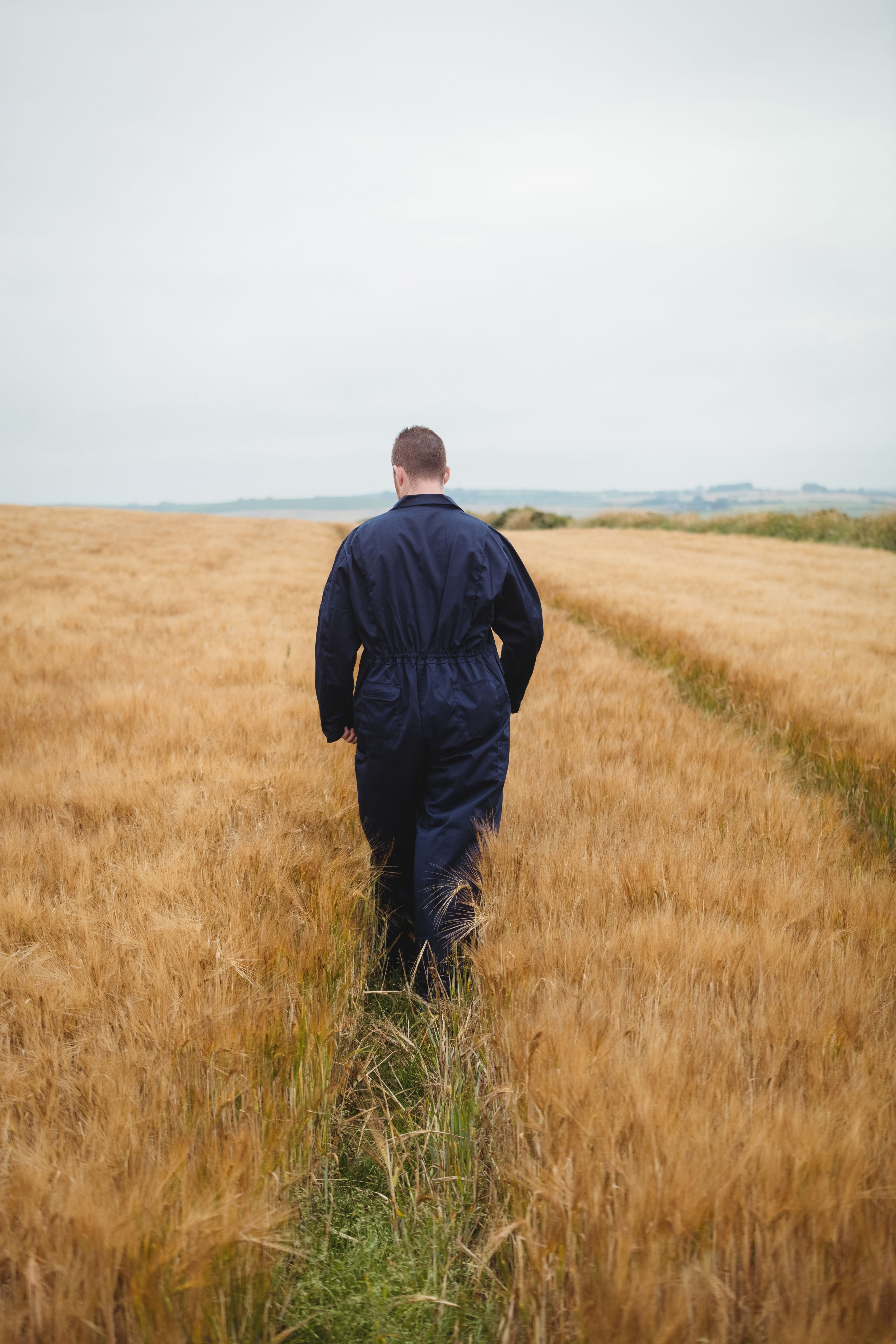 Rear view of farmer walking in the field Rear view of farmer walking in the field