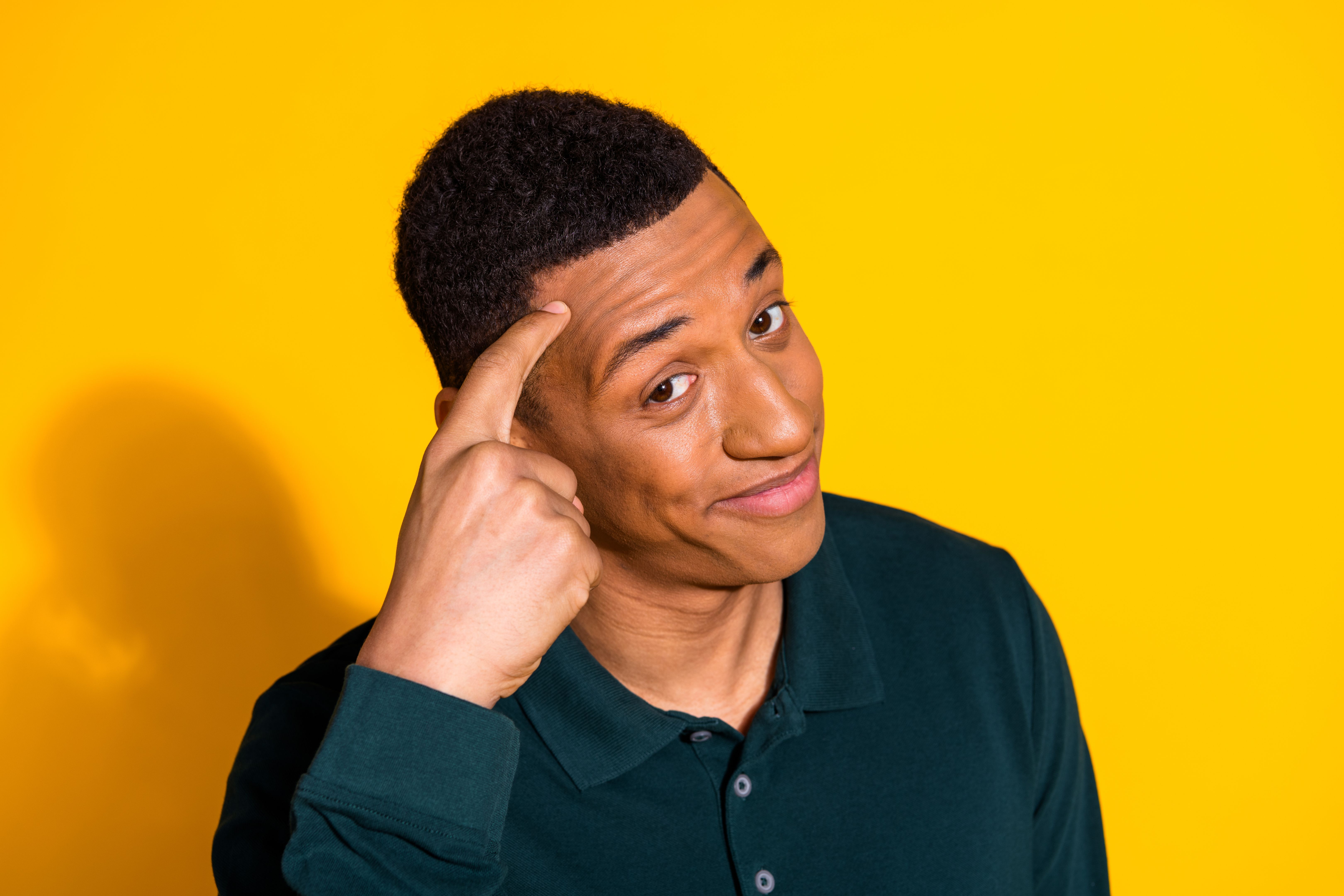 Portrait of nice young man finger touch temple think wear pullover isolated on vibrant yellow color background Portrait of nice young man finger touch temple think wear pullover isolated on vibrant yellow color background