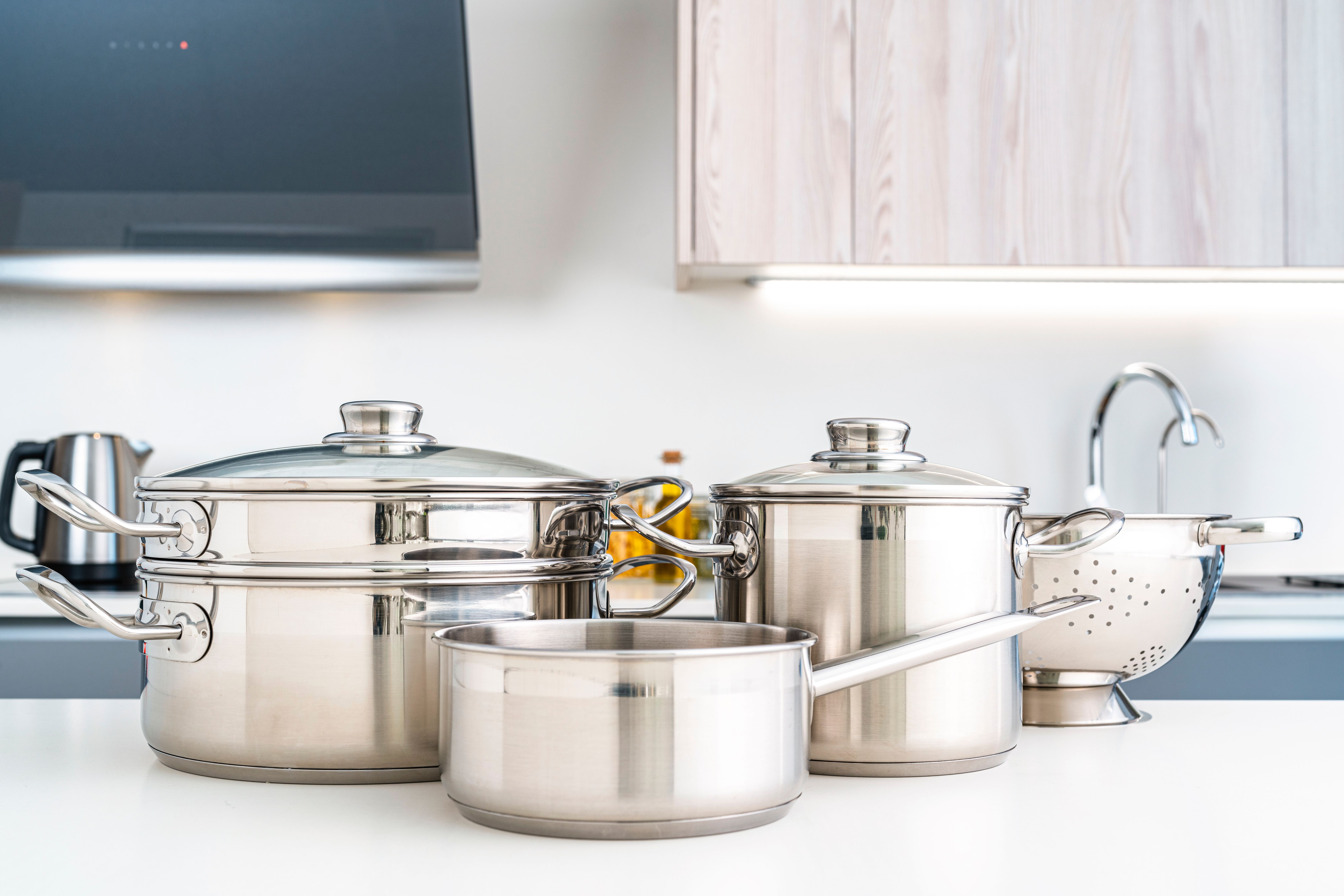 Stainless steel cooking pots on kitchen table