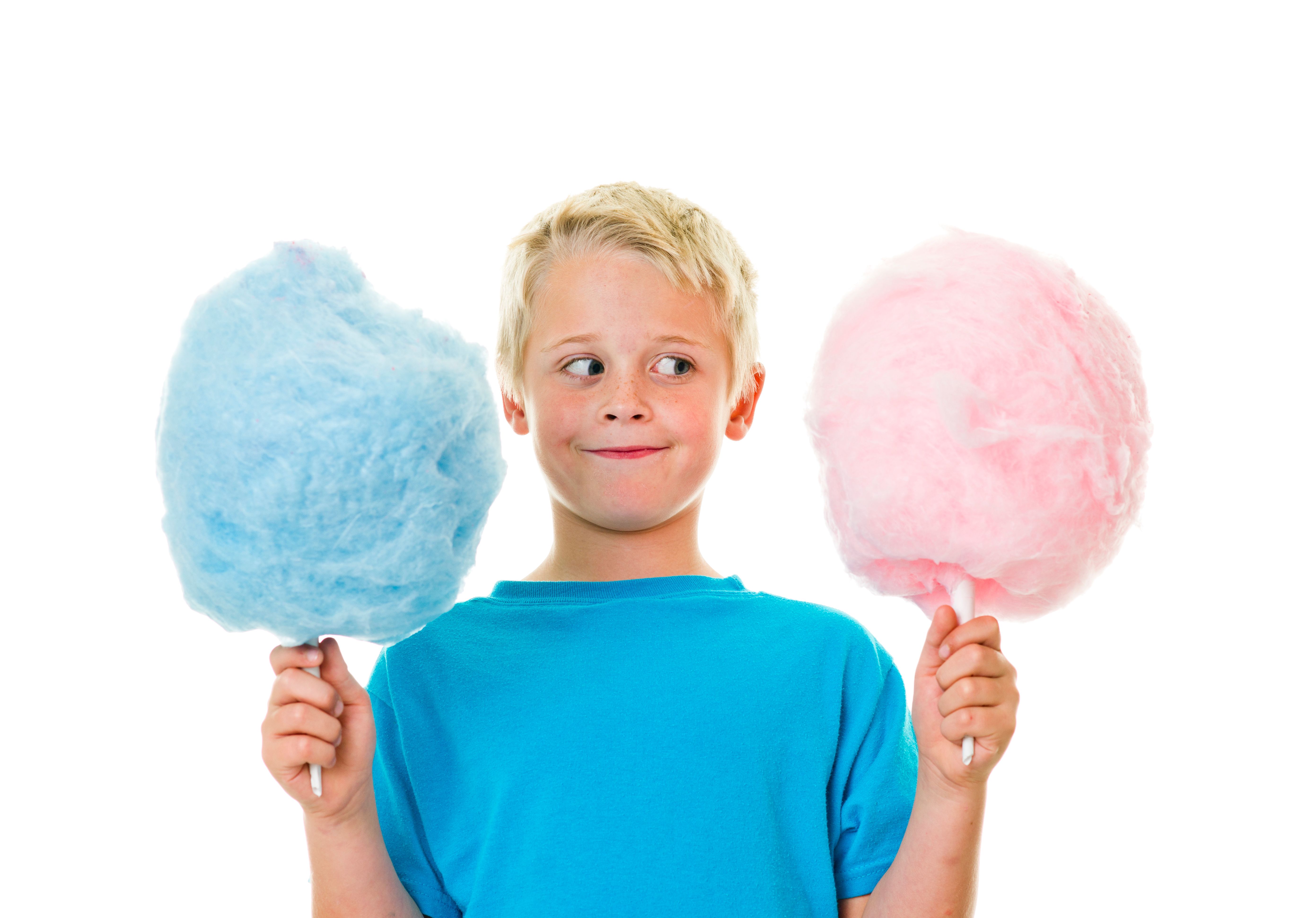 A little boy holding pink and blue cotton candy