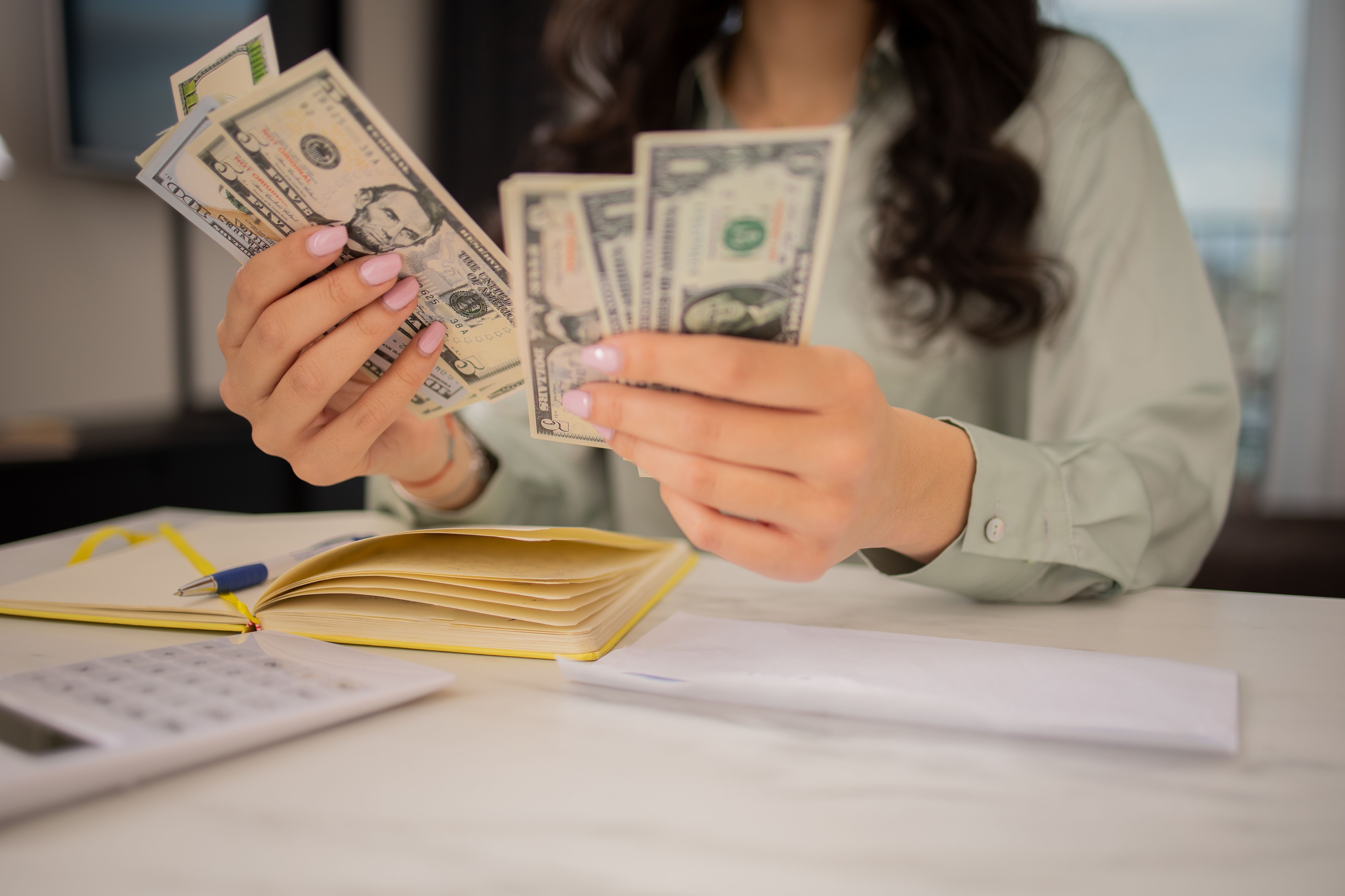 Young woman using calculator while going through bills and home finances