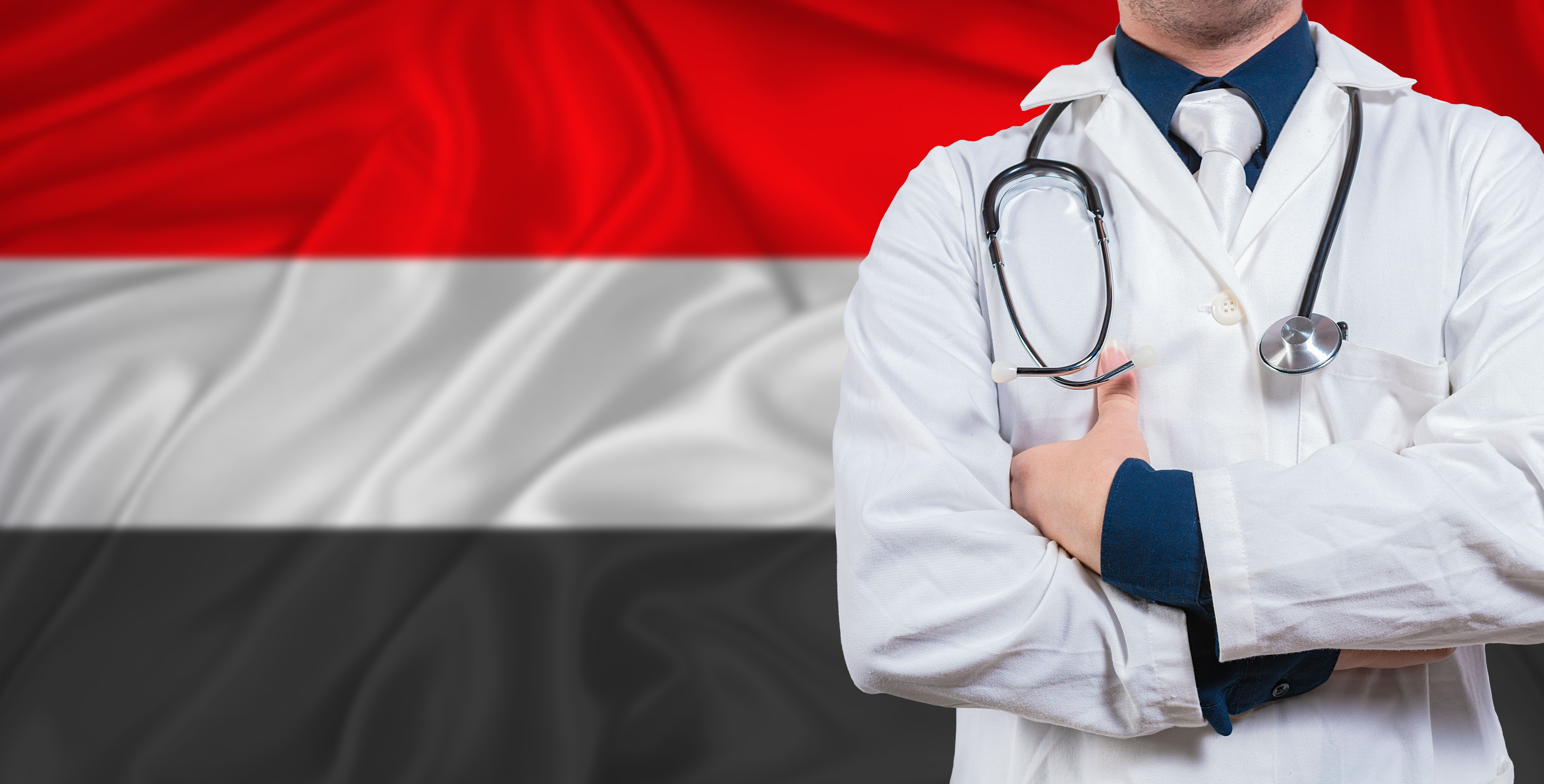 Male doctor with stethoscope on Yemeni flag. Doctor holding stethoscope on Yemen flag
