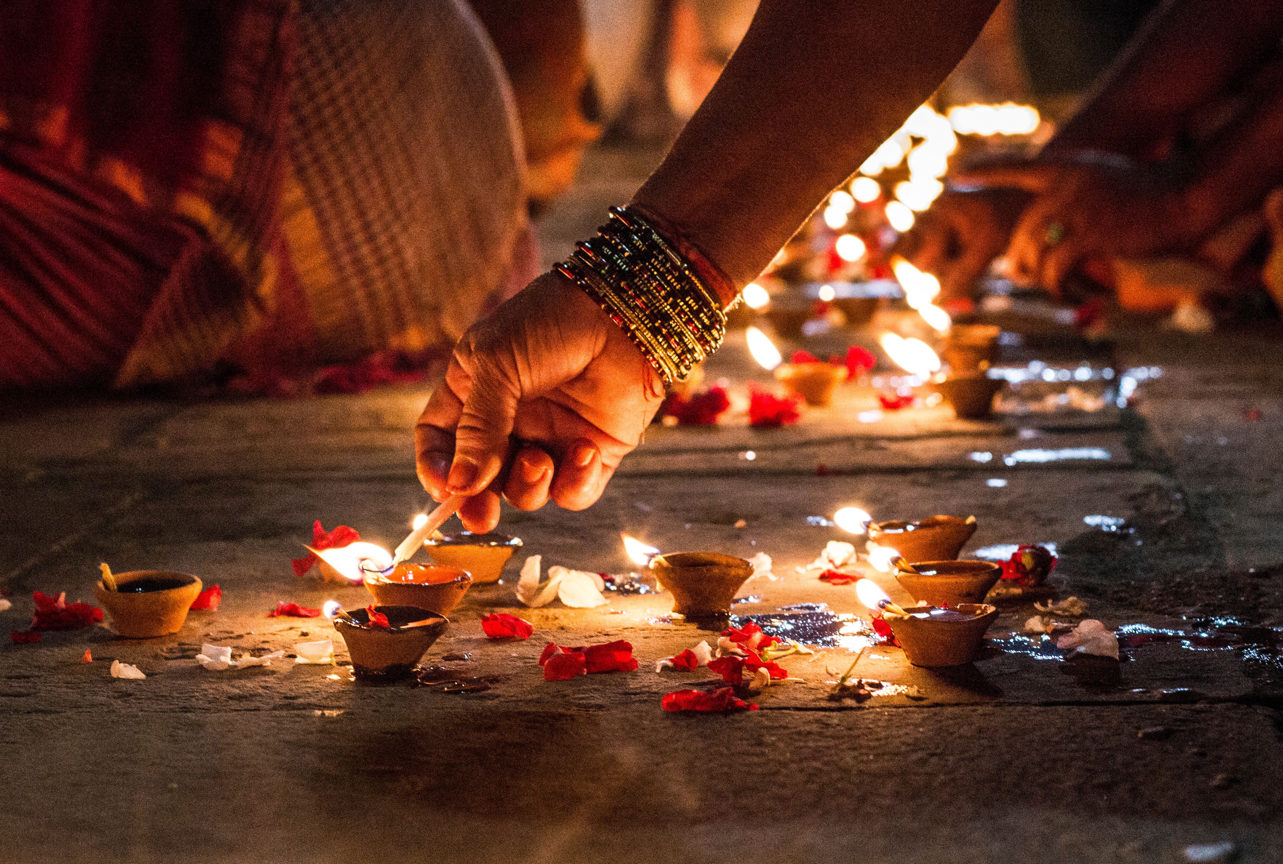 Close-Up Of Hand Holding Illuminated Candles