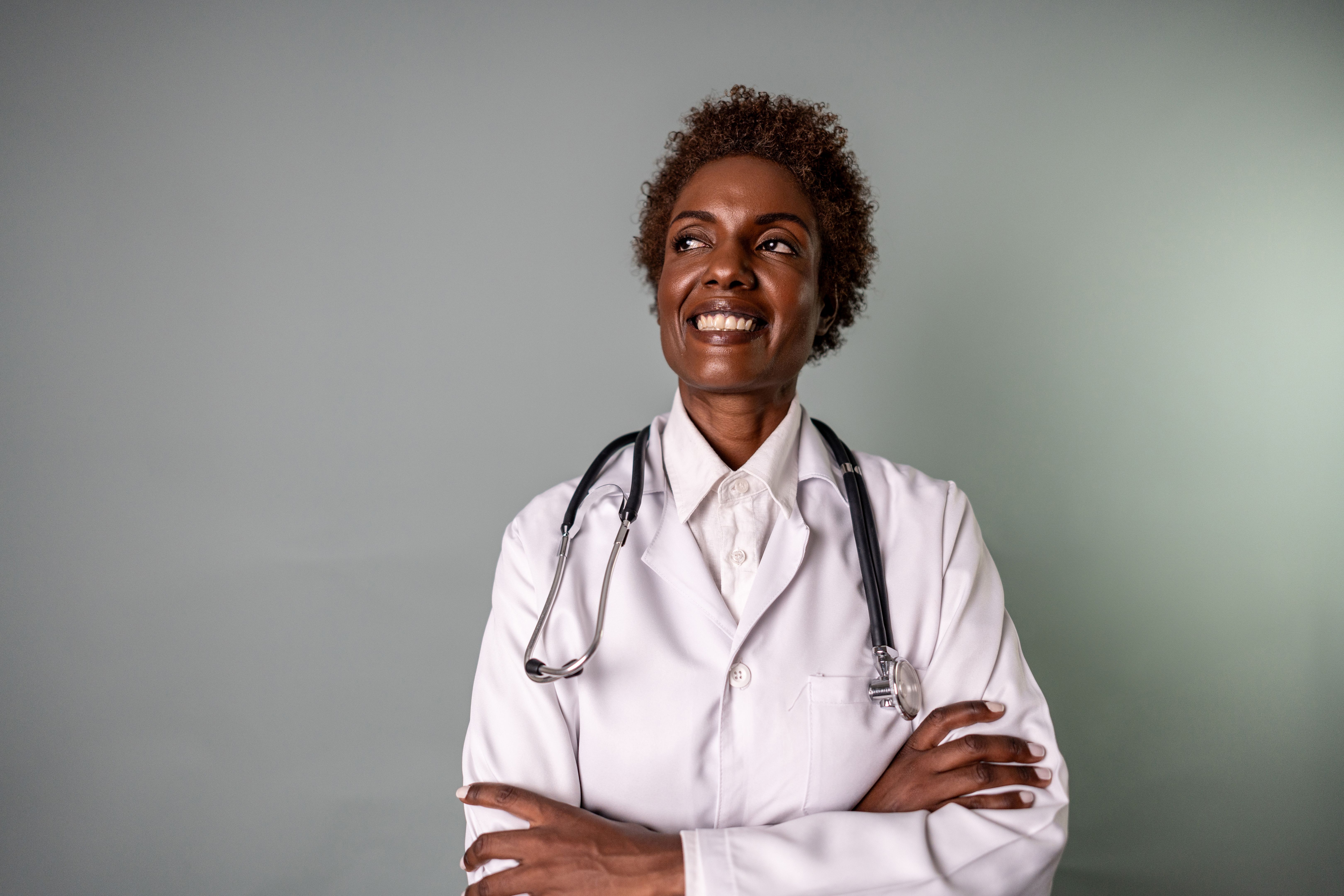 Mature doctor woman contemplating on a studio shot with gray background