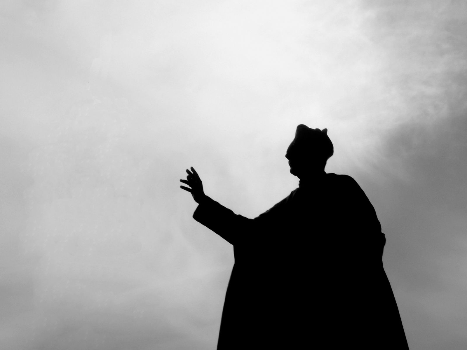 Black and white pope holding hand out and waving