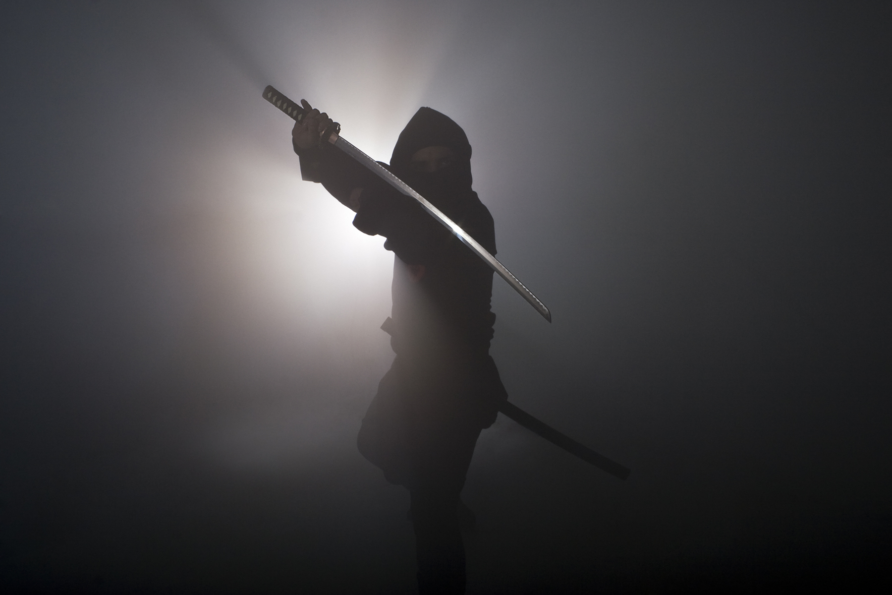 Ninja holding sword in dark fog Ninja holding sword in dark fog
