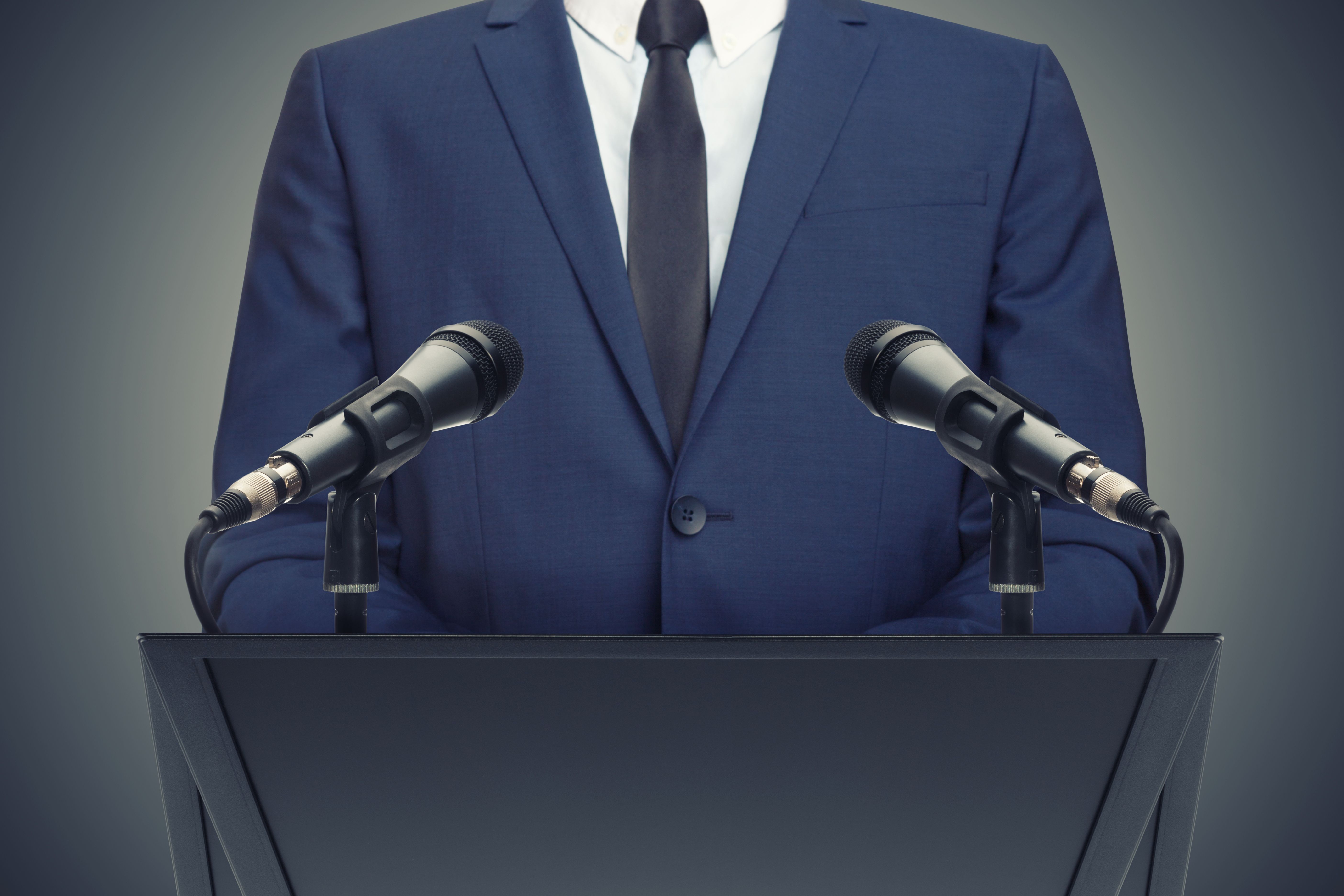 Businessman or politician making speech behind the pulpit Businessman or politician making speech behind the pulpit