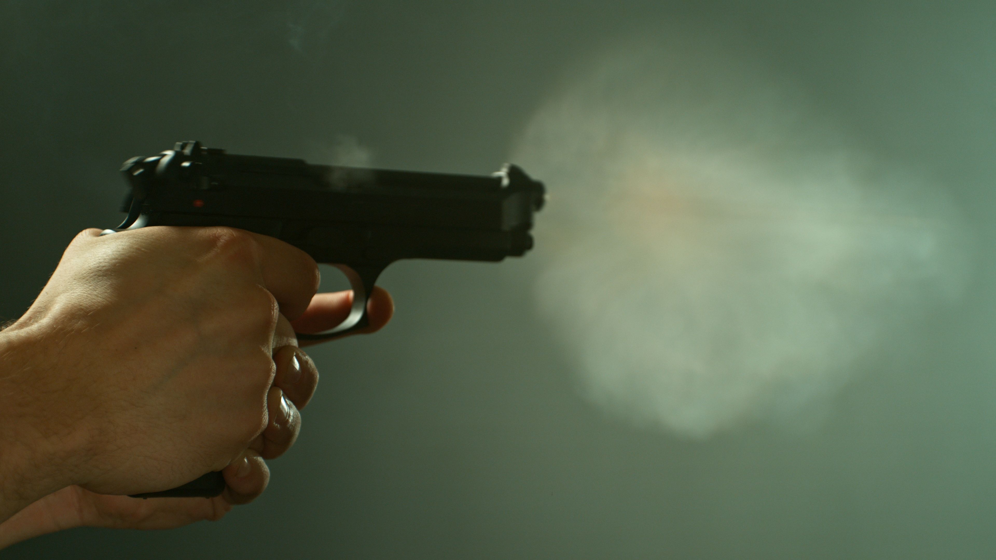 Man Shooting a Pistol on Dark Background