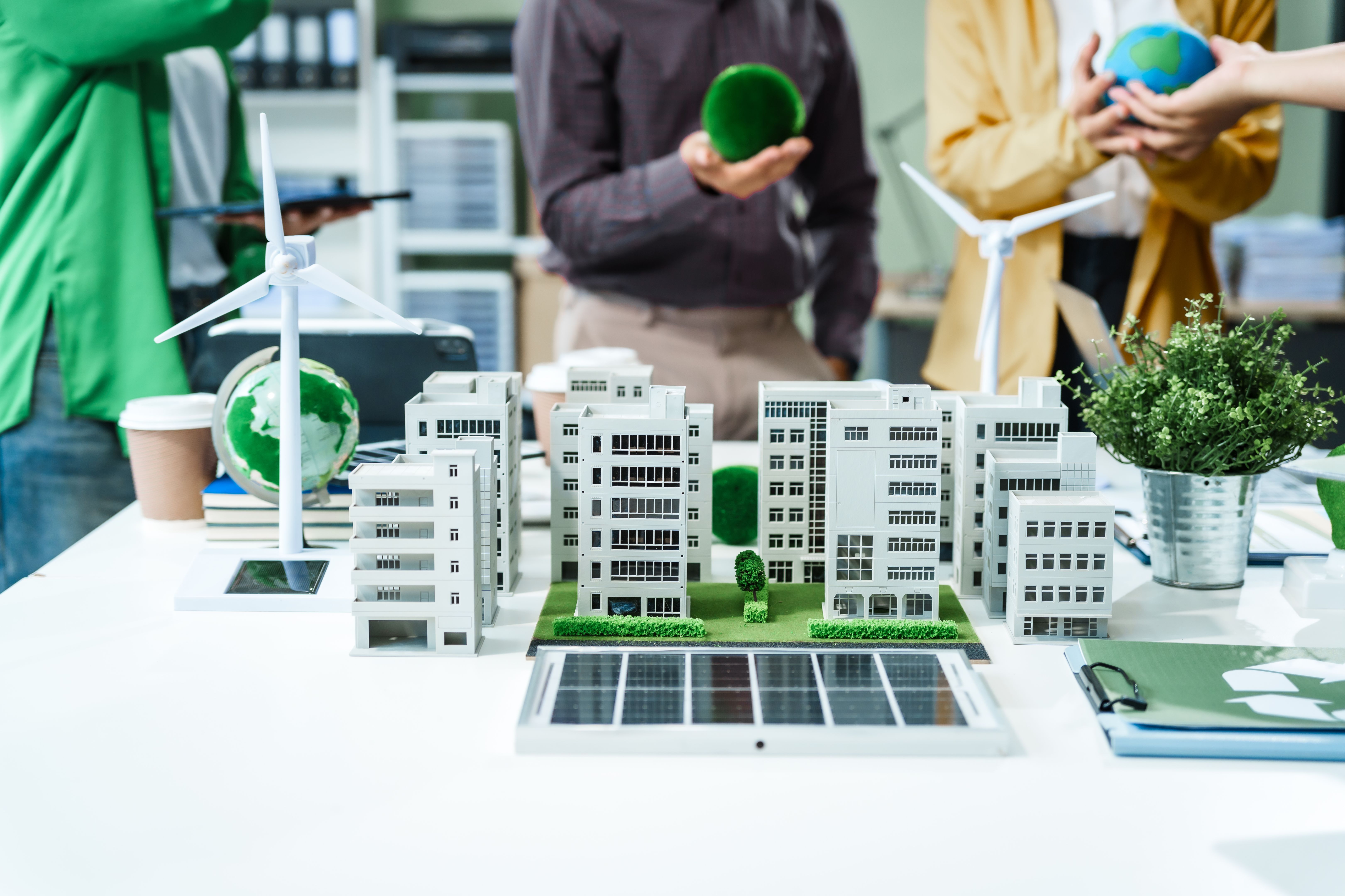 Colleagues in formal suits meet at desk to brainstorm environmental management strategies. discuss carbon emissions, renewable energy, sustainable business practices to reduce corporate footprint. Colleagues in formal suits meet at desk to brainstorm environmental management strategies. discuss carbon emissions, renewable energy, sustainable business practices to reduce corporate footprint.