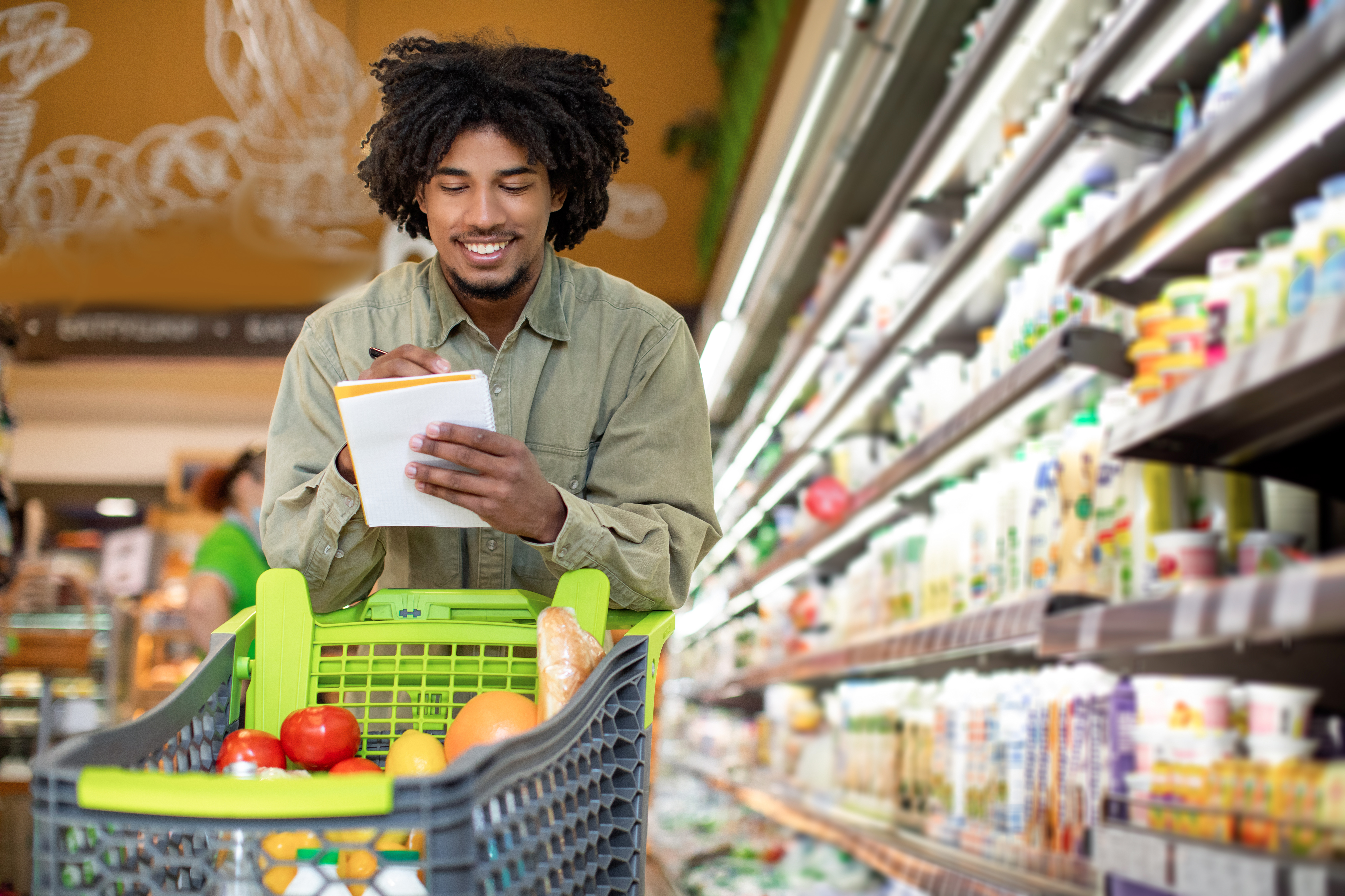 Black Guy Holding Shopping List Taking Notes In Supermarket