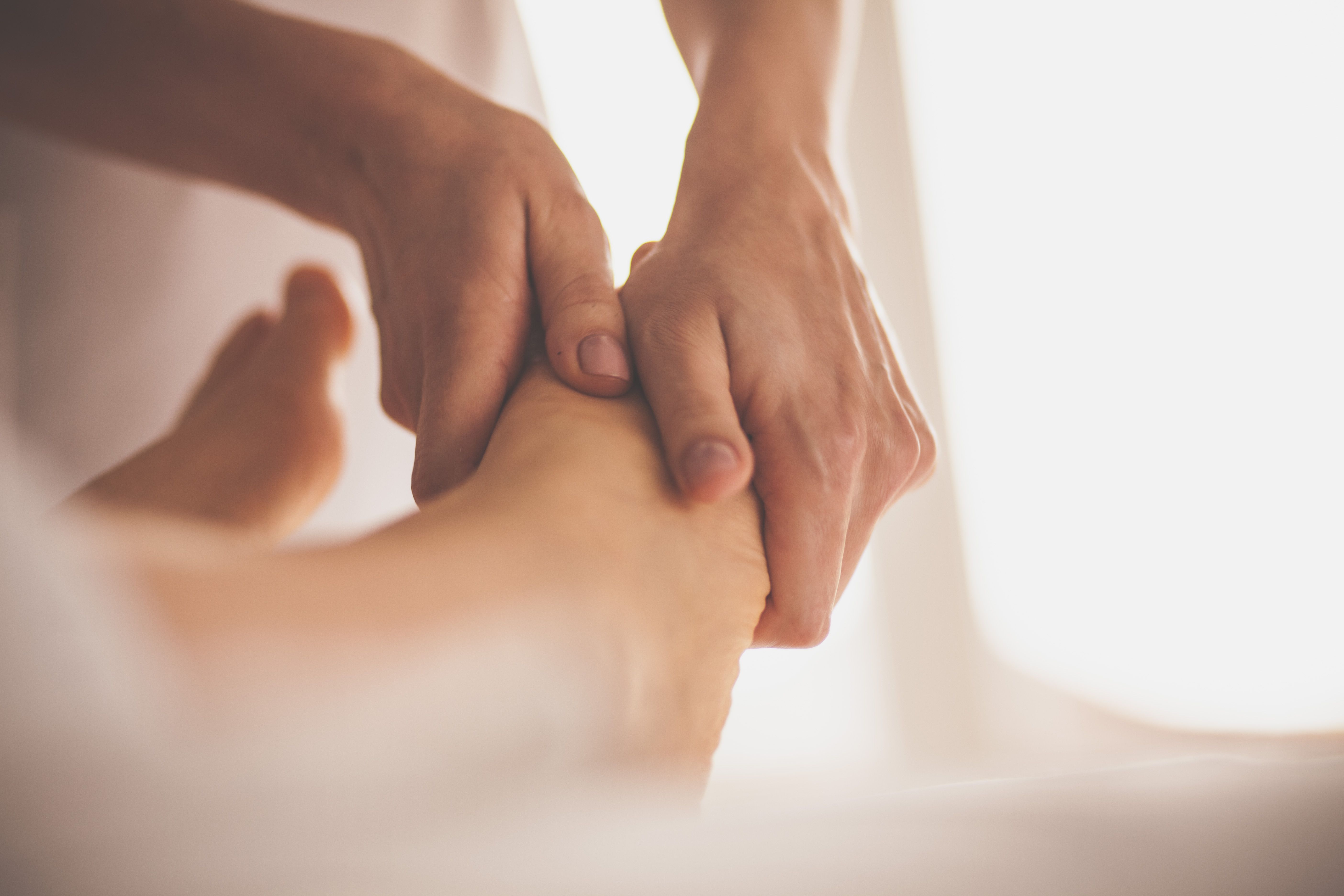 Massage therapist massaging woman's feet