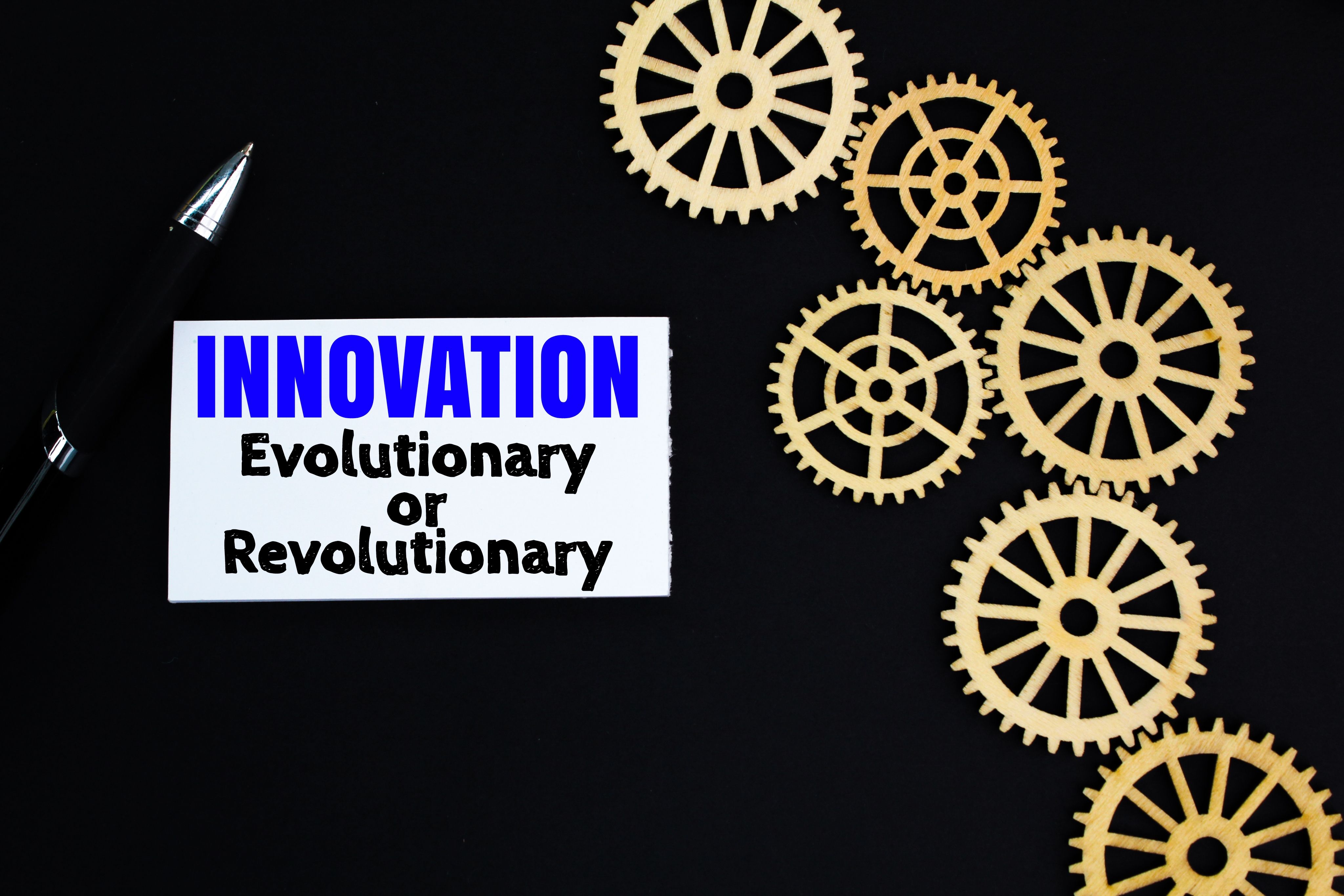 gear teeth and white paper with the words Innovation Evolutionary or Revolutionary. gear teeth and white paper with the words Innovation Evolutionary or Revolutionary.