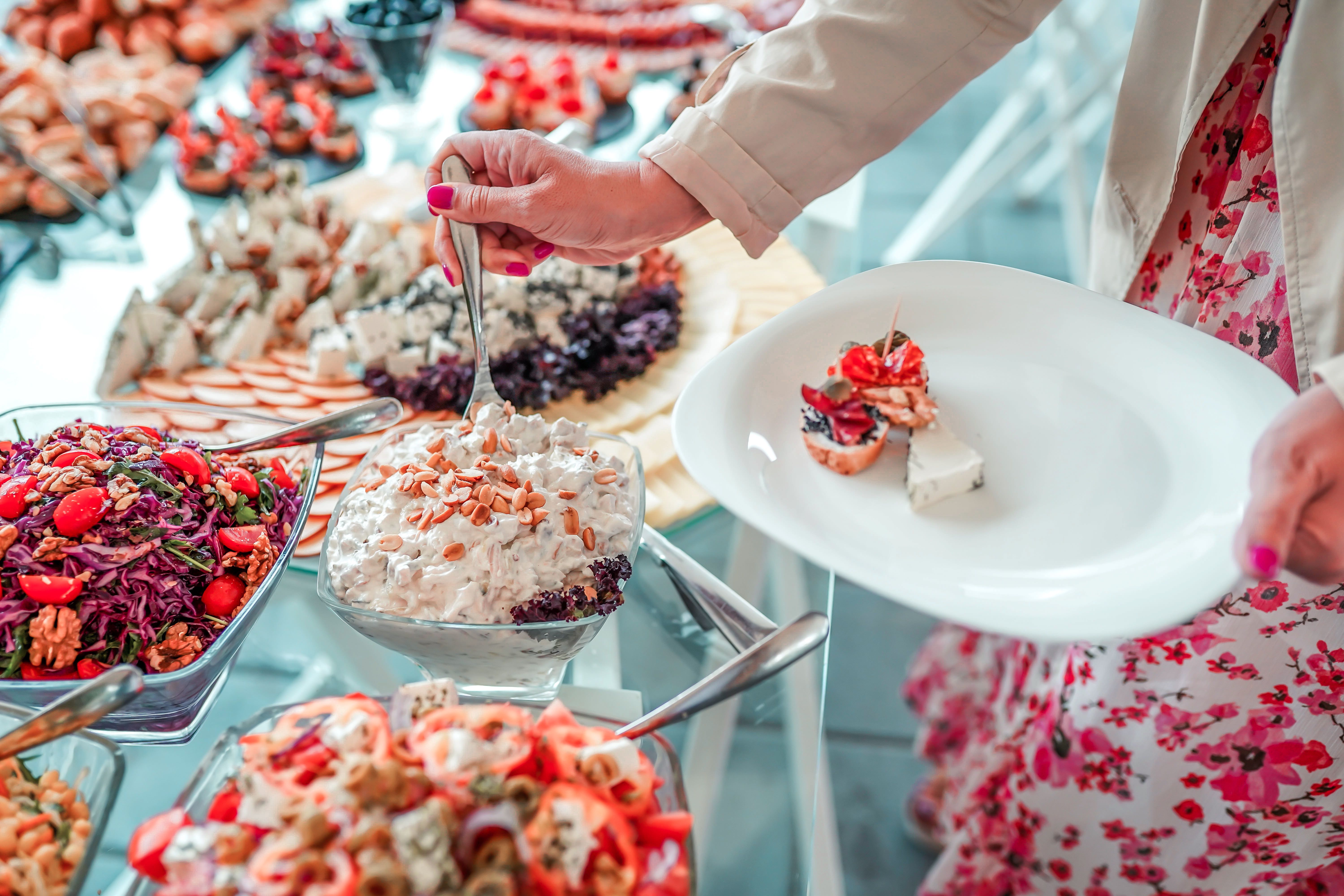 Woman holding plate and taking food from buffet table during breakfast in hotel Woman holding plate and taking food from buffet table during breakfast in hotel