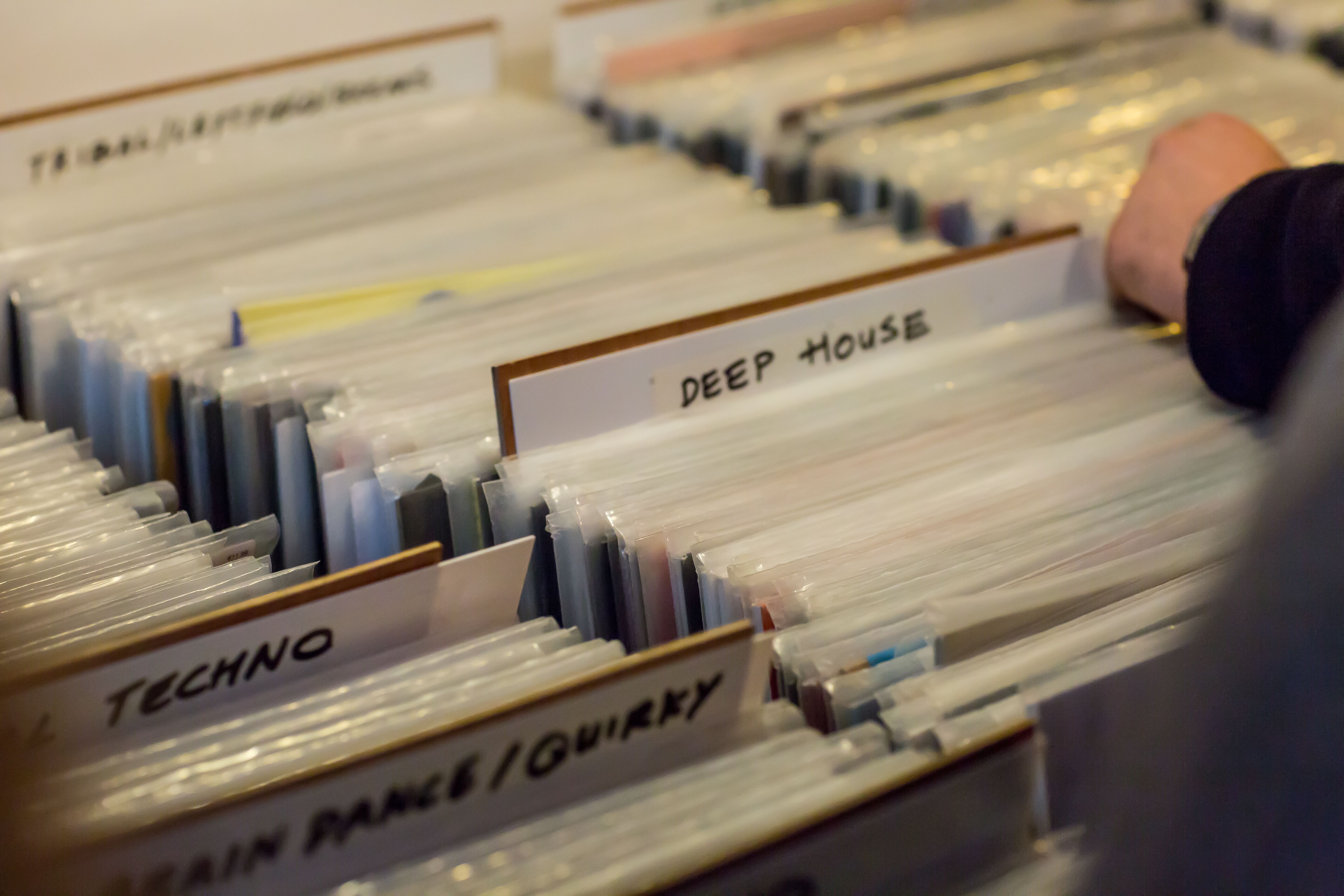 Women's hands browsing records in a vinyl record store
